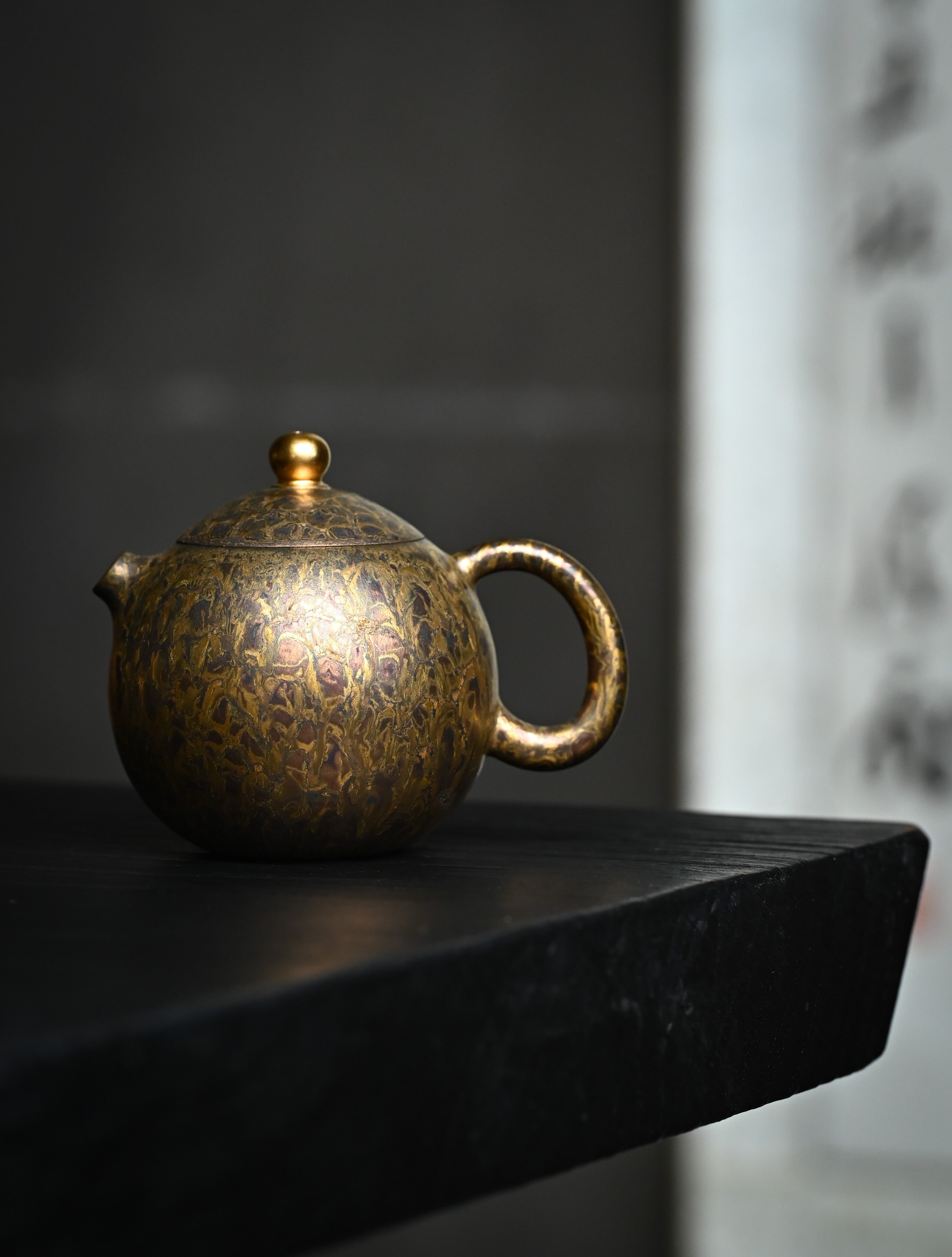 YANYOO handmade Yixing teapot featuring Feather-Plume firing technique, Dragon Egg, lifestyle wide-angle left side.