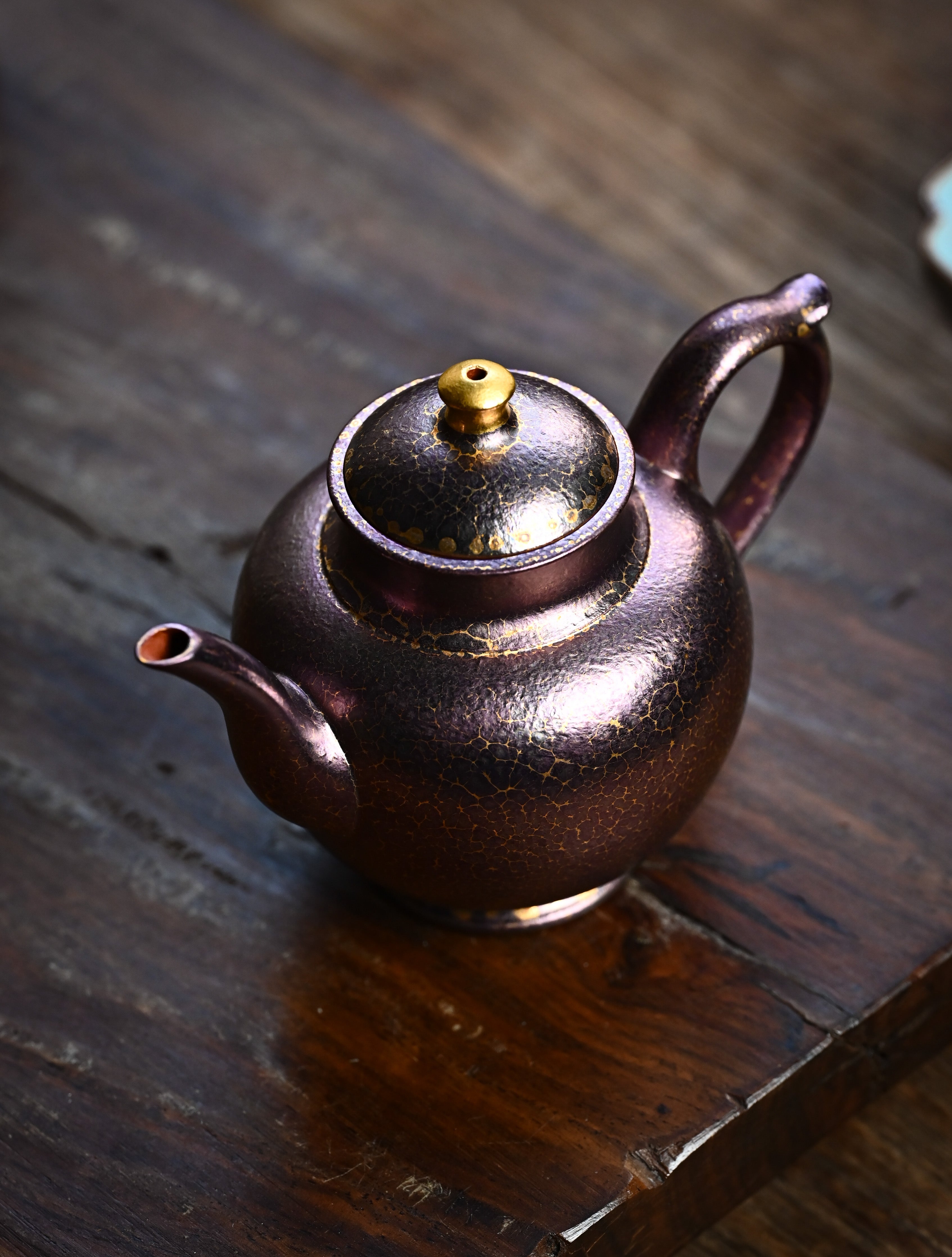 YANYOO handmade Yixing teapot featuring Feather-Plume firing technique, Flask purple gold, lifestyle left side.