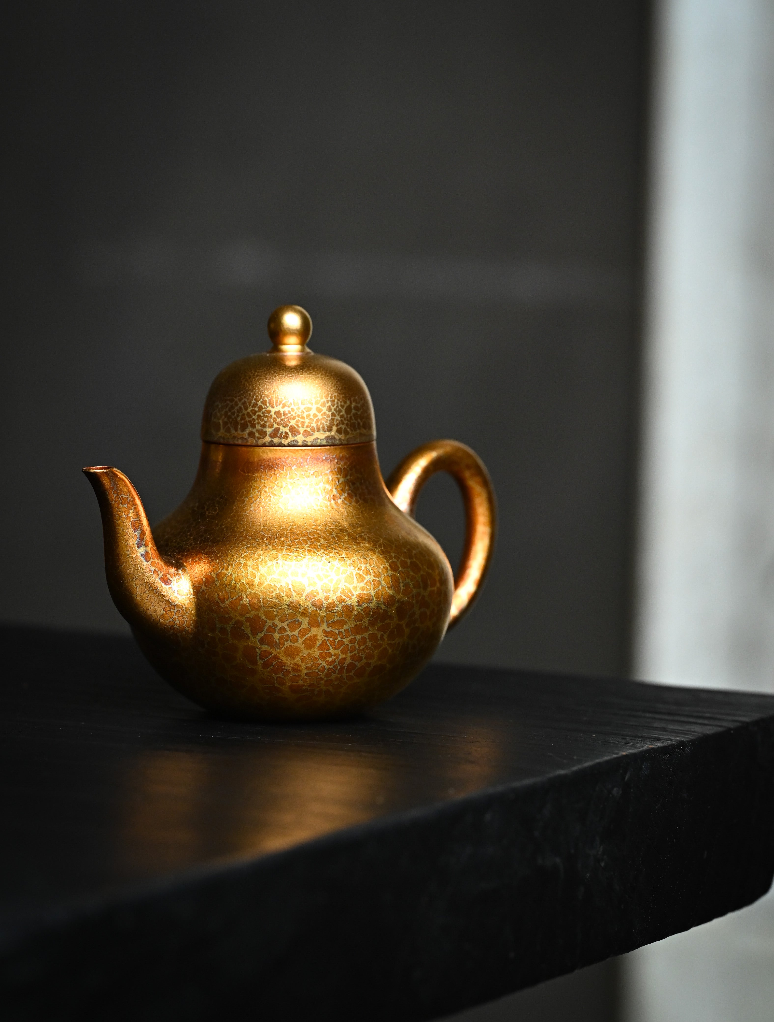 YANYOO handmade Yixing teapot featuring Feather-Plume firing technique, Si Ting gold, lifestyle front side.