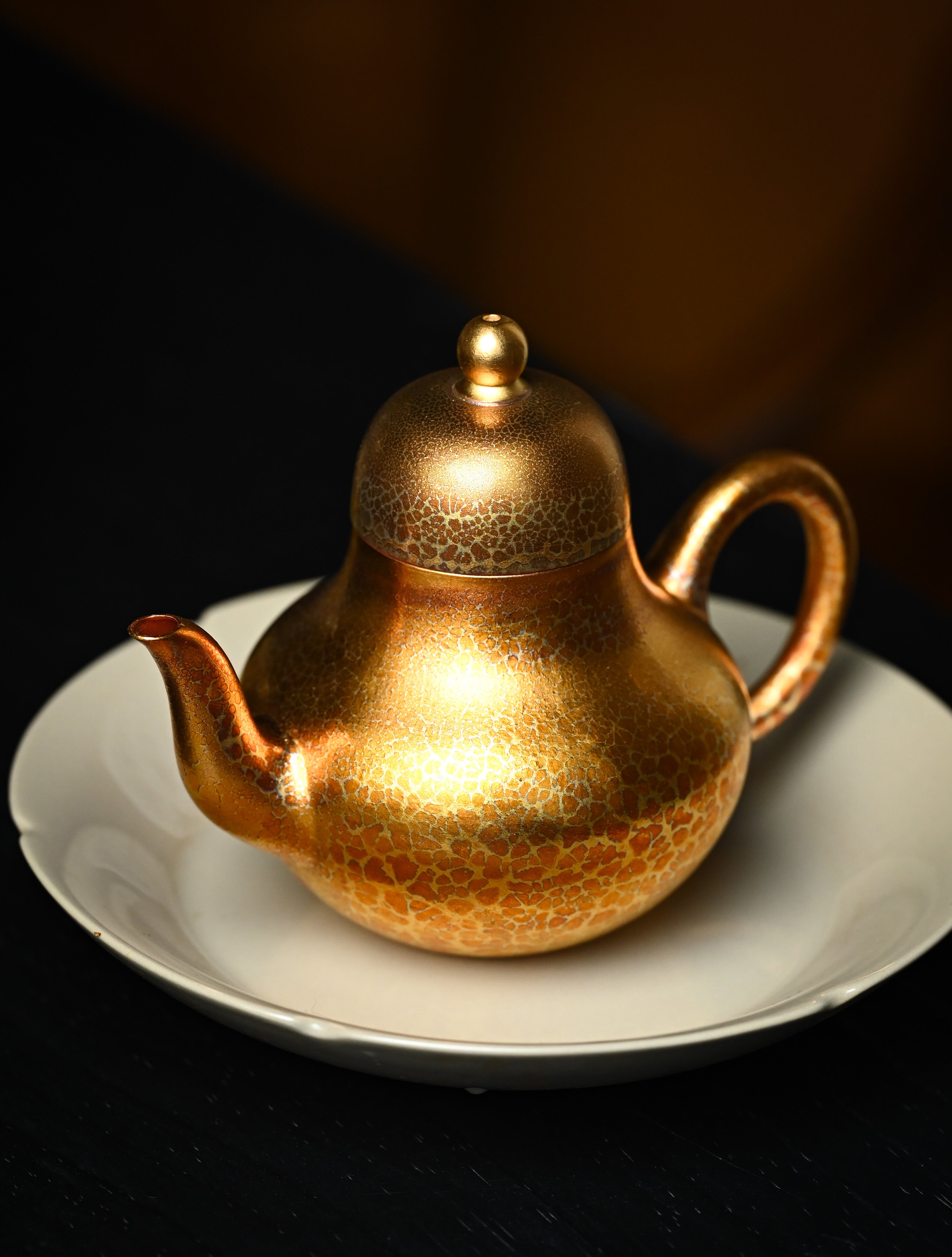 YANYOO handmade Yixing teapot featuring Feather-Plume firing technique, Si Ting gold, lifestyle left side.