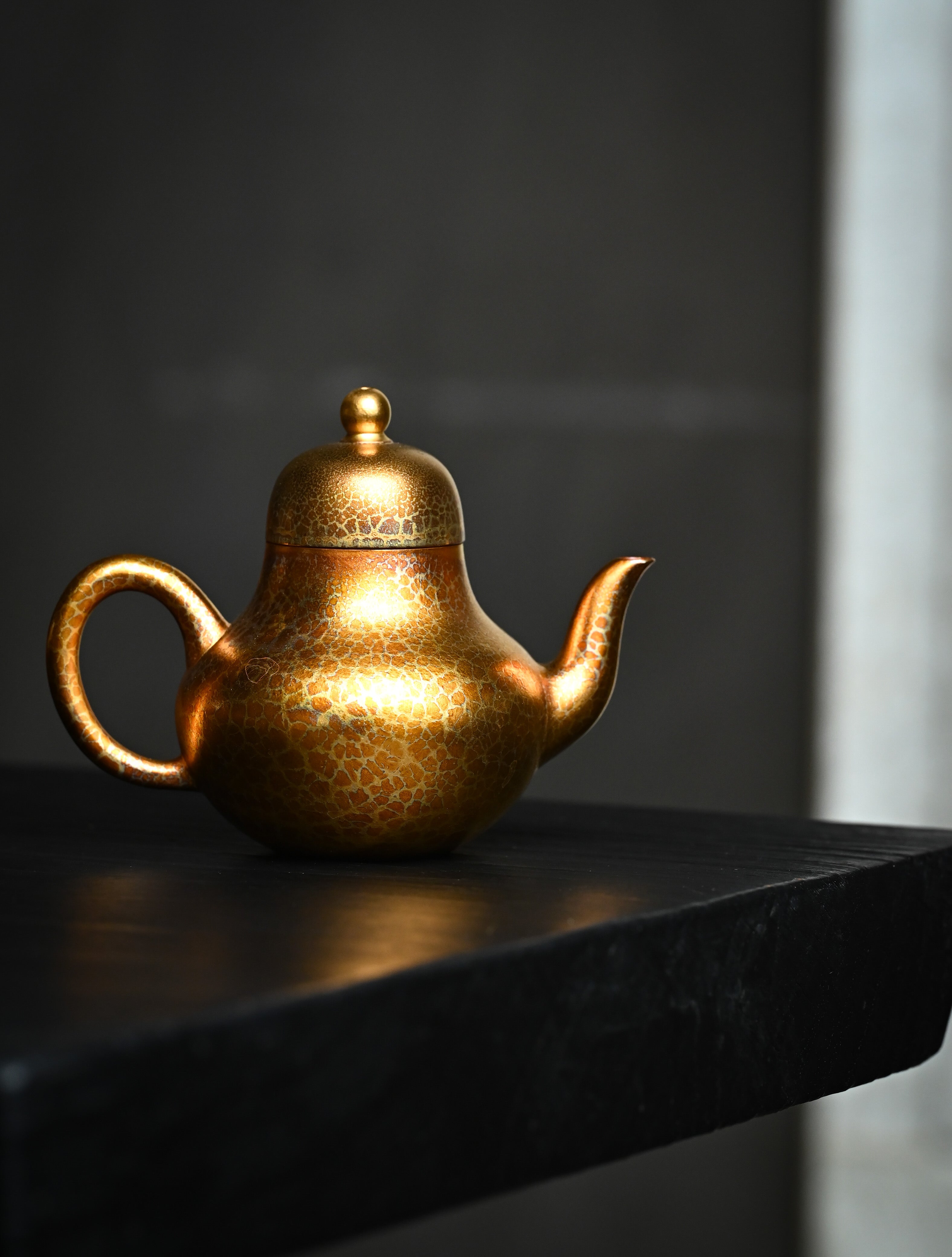 YANYOO handmade Yixing teapot featuring Feather-Plume firing technique, Si Ting gold, lifestyle wide-angle right side.