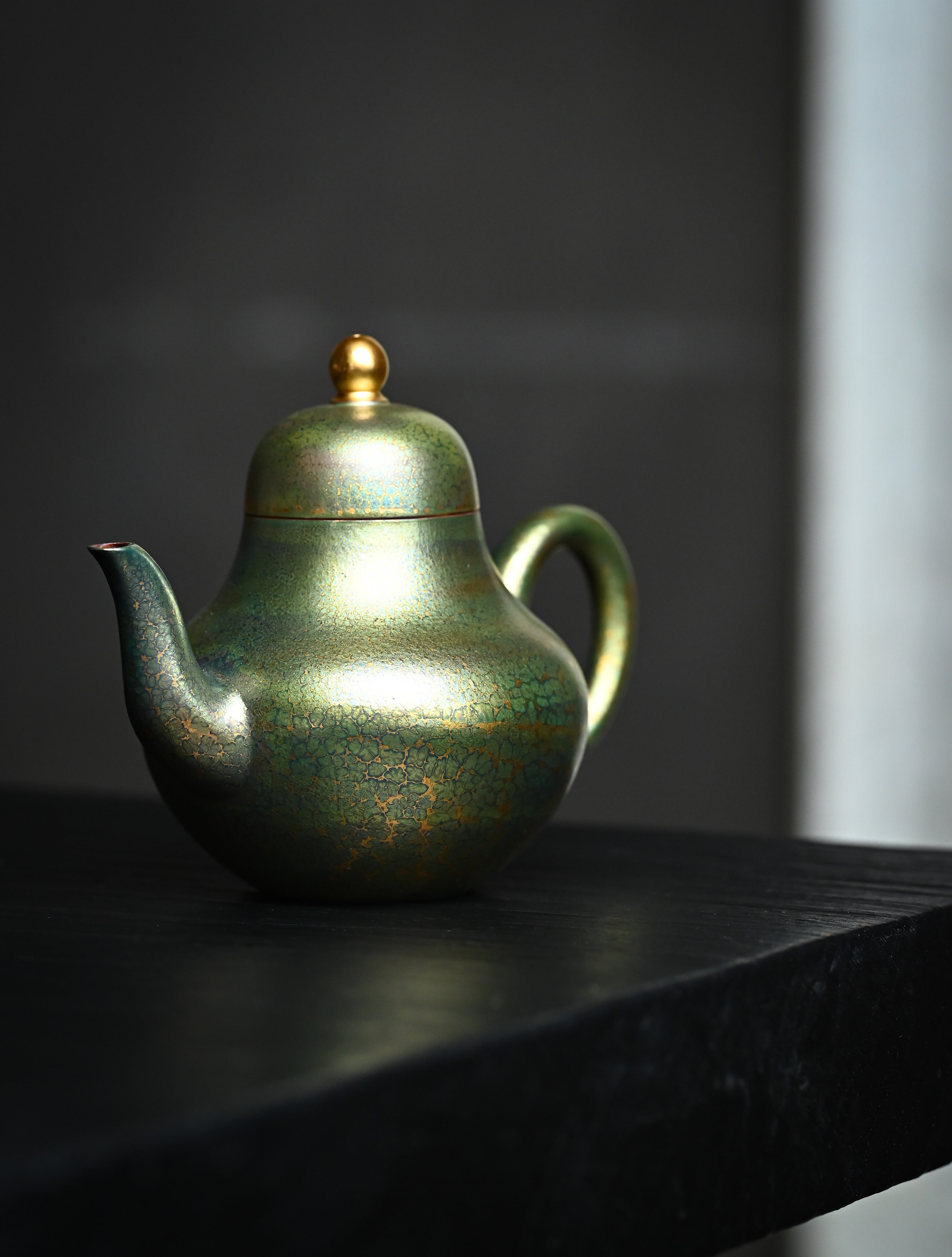 YANYOO handmade Yixing teapot featuring Feather-Plume firing technique, Si Ting green, lifestyle front side.