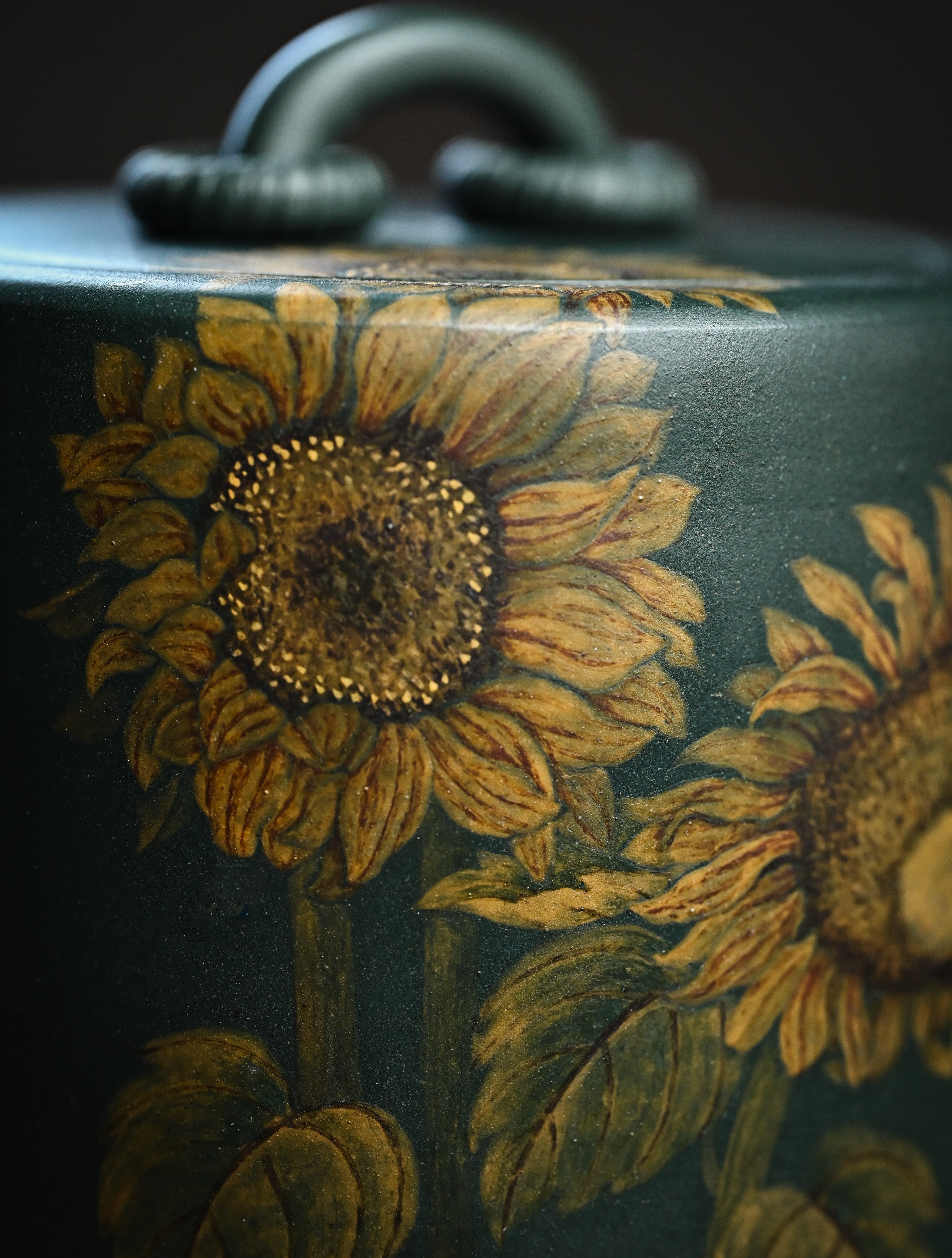 YANYOO handmade Yixing teapot featuring aged green clay and embedded painting of sunflower by Master Xuanzi, lifestyle detail front side.