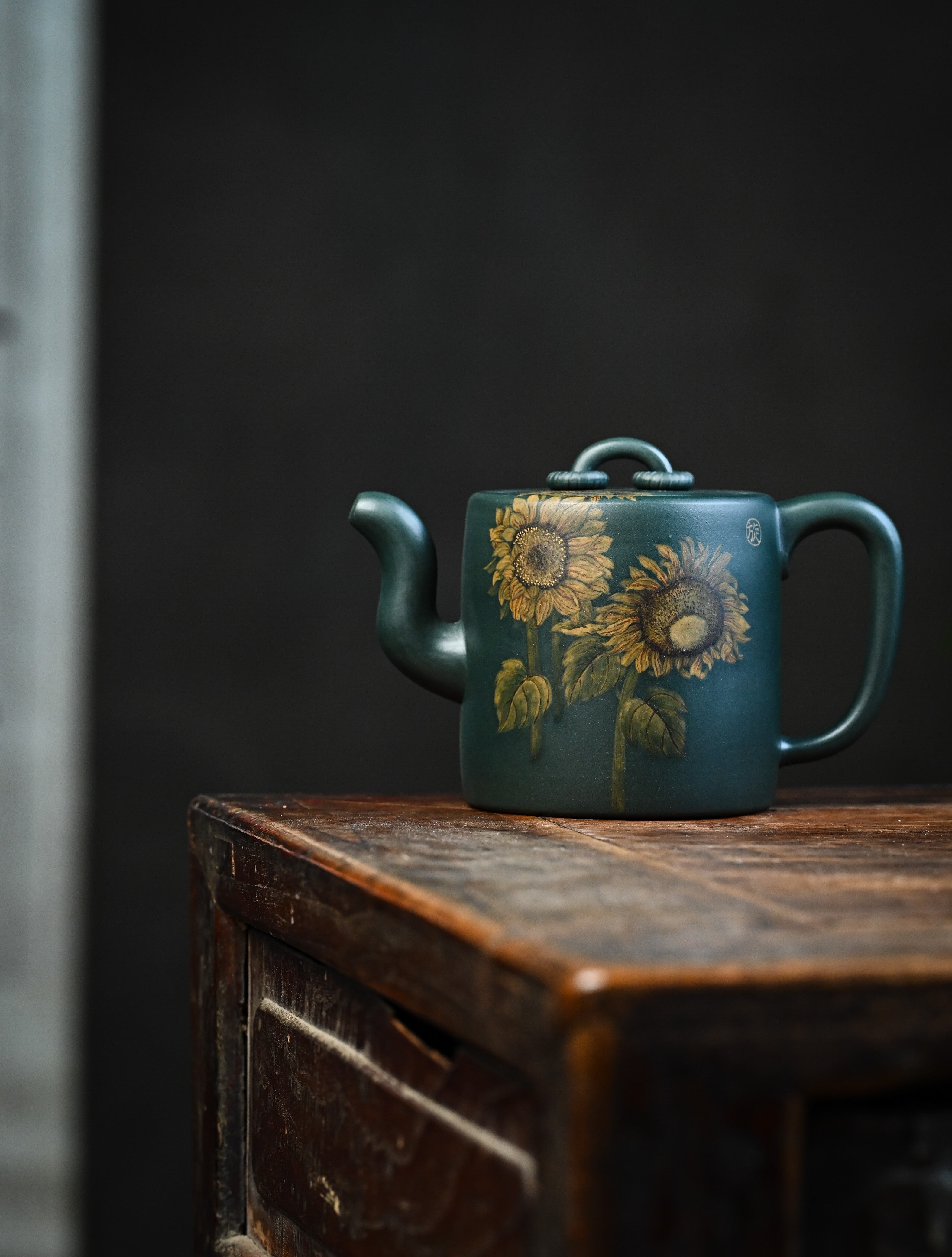 YANYOO handmade Yixing teapot featuring aged green clay and embedded painting of sunflower by Master Xuanzi, lifestyle wide-angle left side.