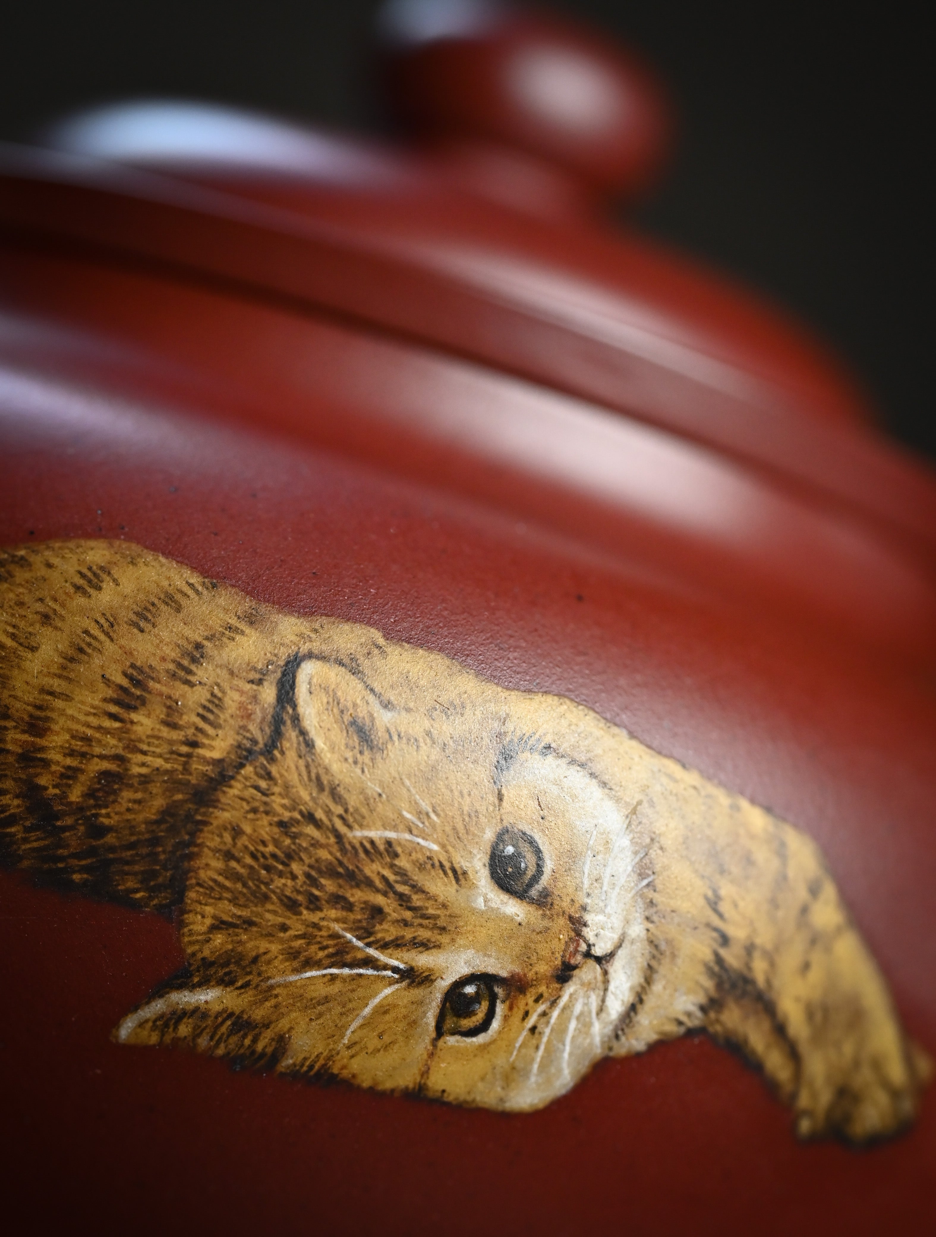 YANYOO handmade Yixing teapot featuring Hong Pi Long clay and embedded painting of cat by Master Xuanzi, lifestyle detail front.