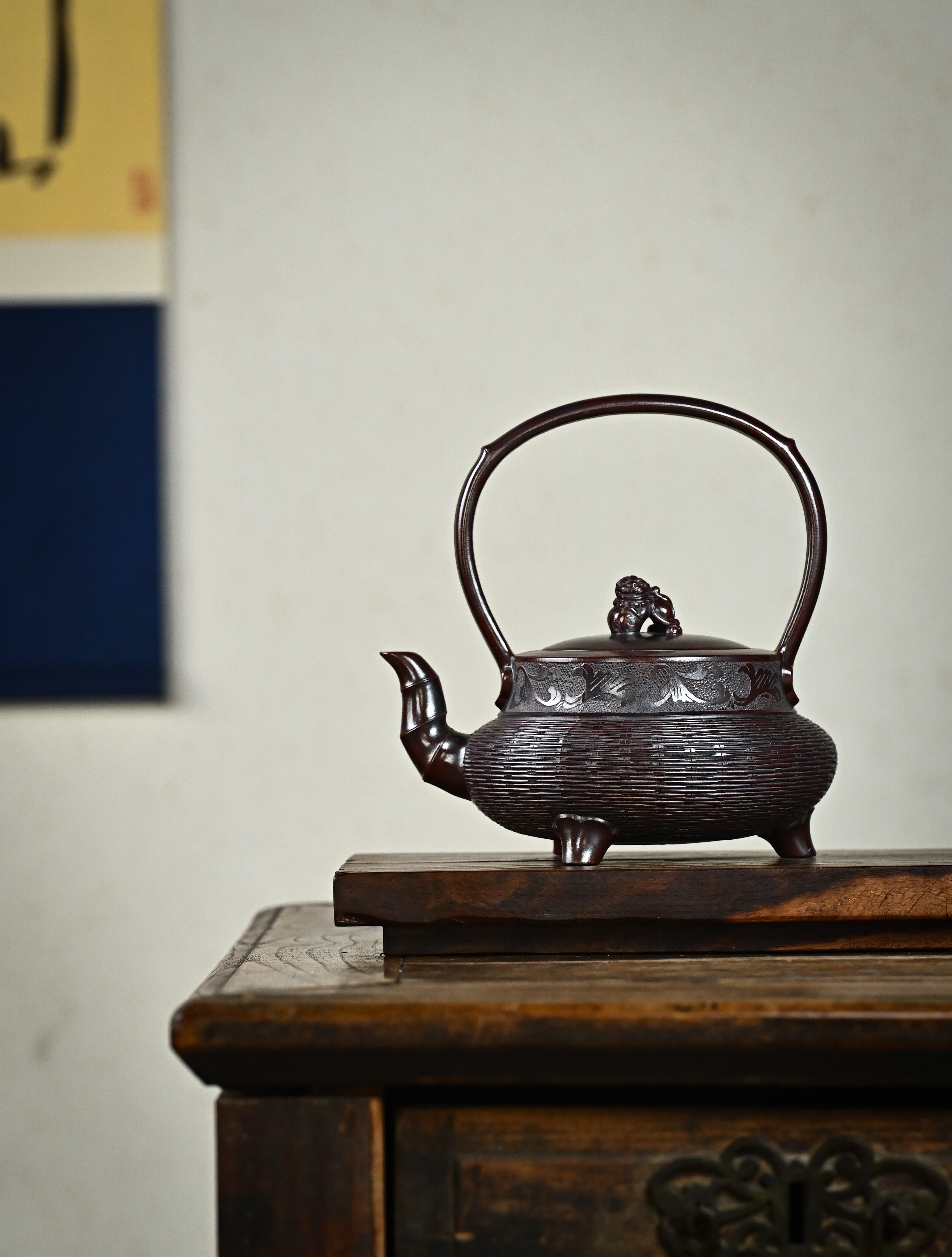 YANYOO handcrafted Yixing teapot featuring aged Wuni clay, bamboo weaving technique and delicate lifting handle, Lifting Tripod, lifestyle wide-angle left side.