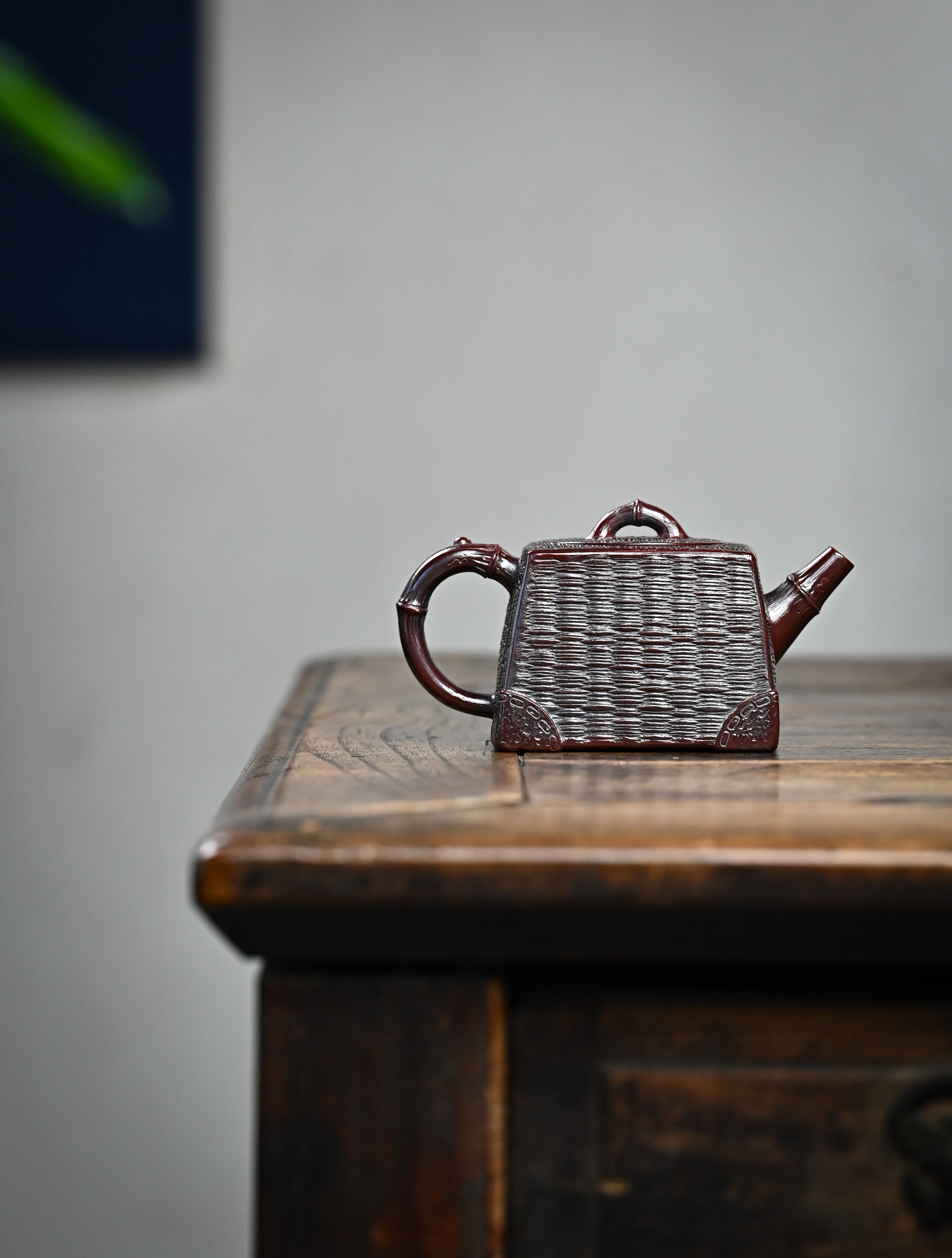 YANYOO handcrafted Yixing teapot featuring aged Wuni clay, bamboo weaving technique and a unique square shape, Si Fang, lifestyle wide-angle right side.