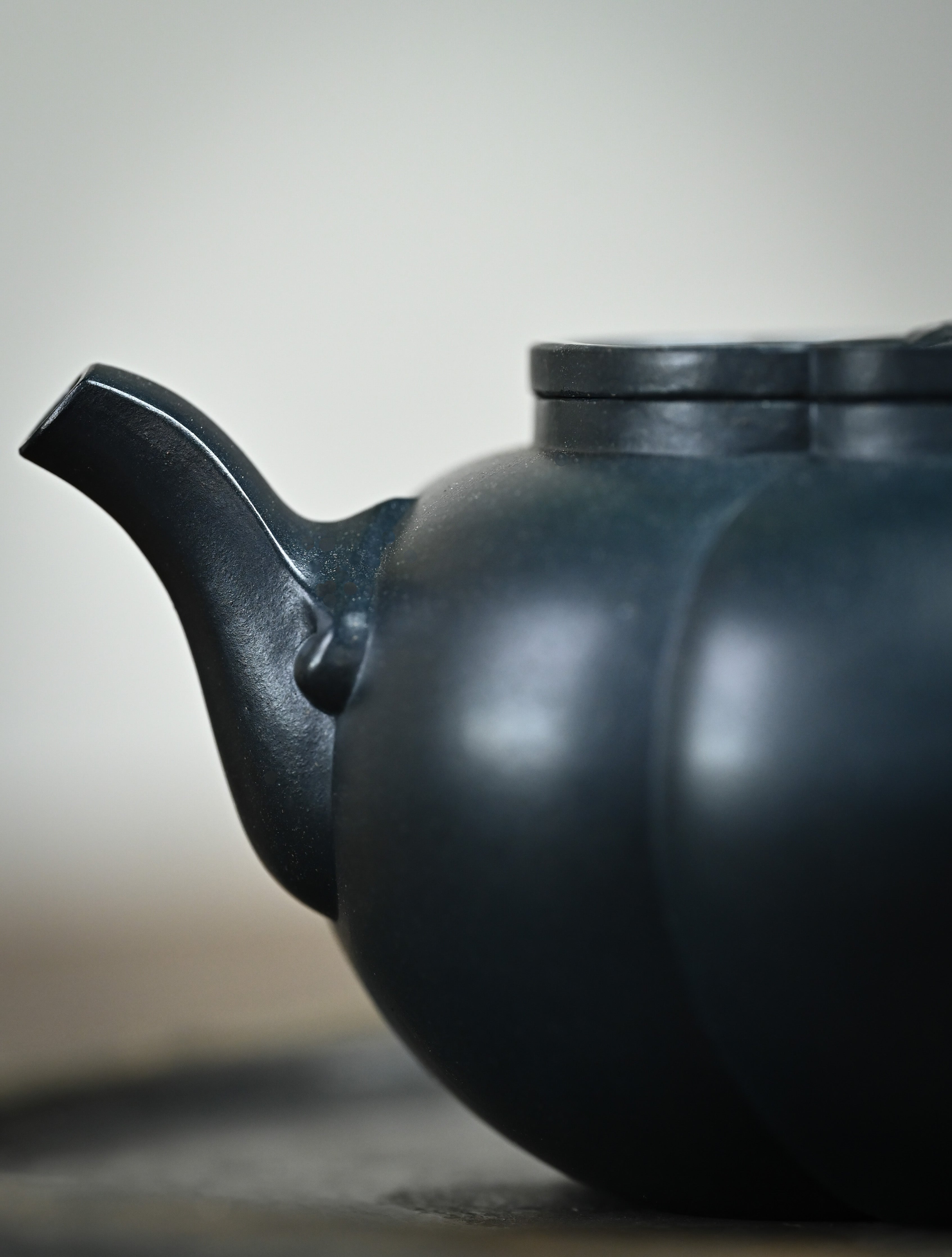 YANYOO handmade Yixing teapot featuring "Que Tou Qing" lvni clay and a ribbed shape, Hai Tang, lifestyle detail front side.