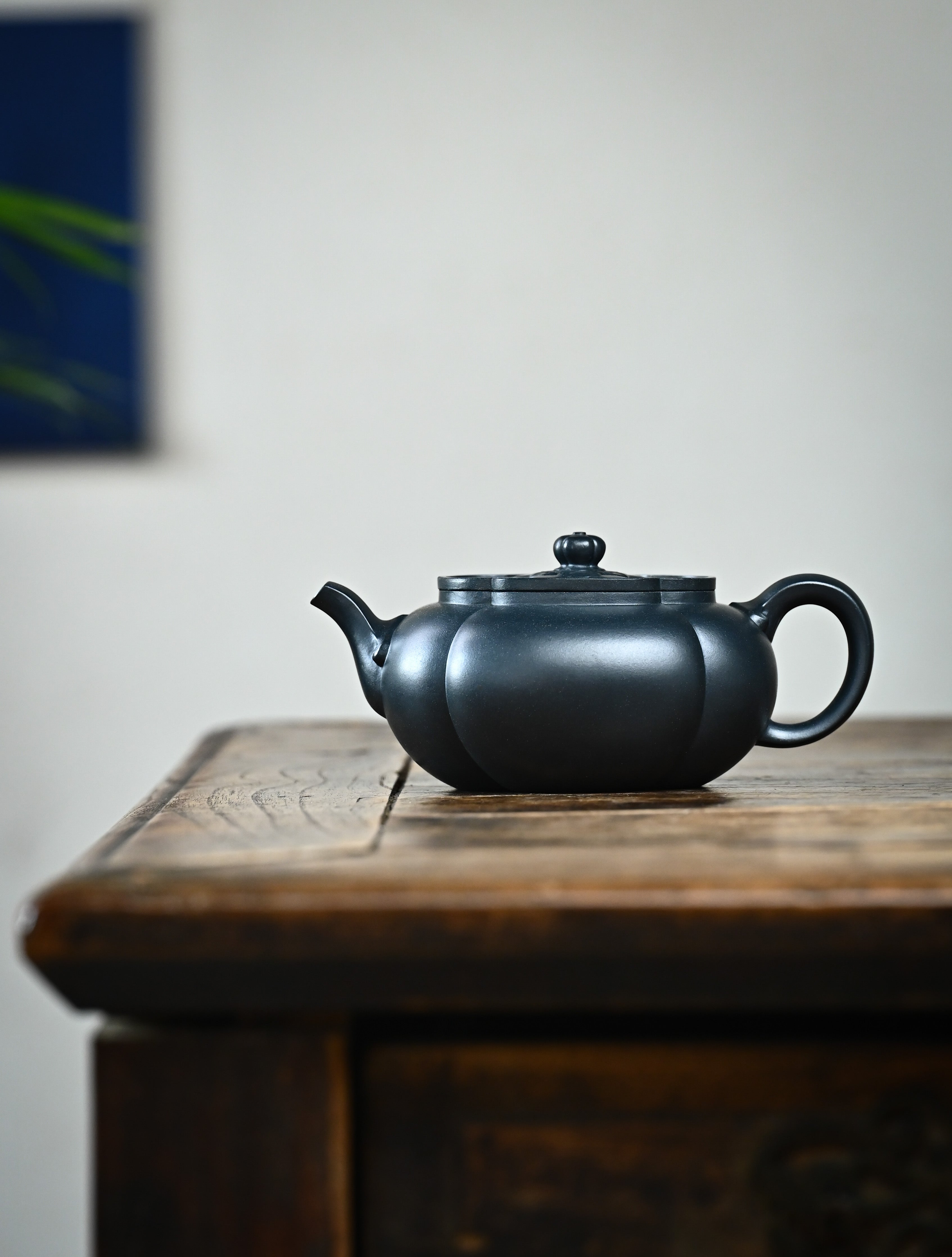 YANYOO handmade Yixing teapot featuring "Que Tou Qing" lvni clay and a ribbed shape, Hai Tang, lifestyle wide-angle left side.
