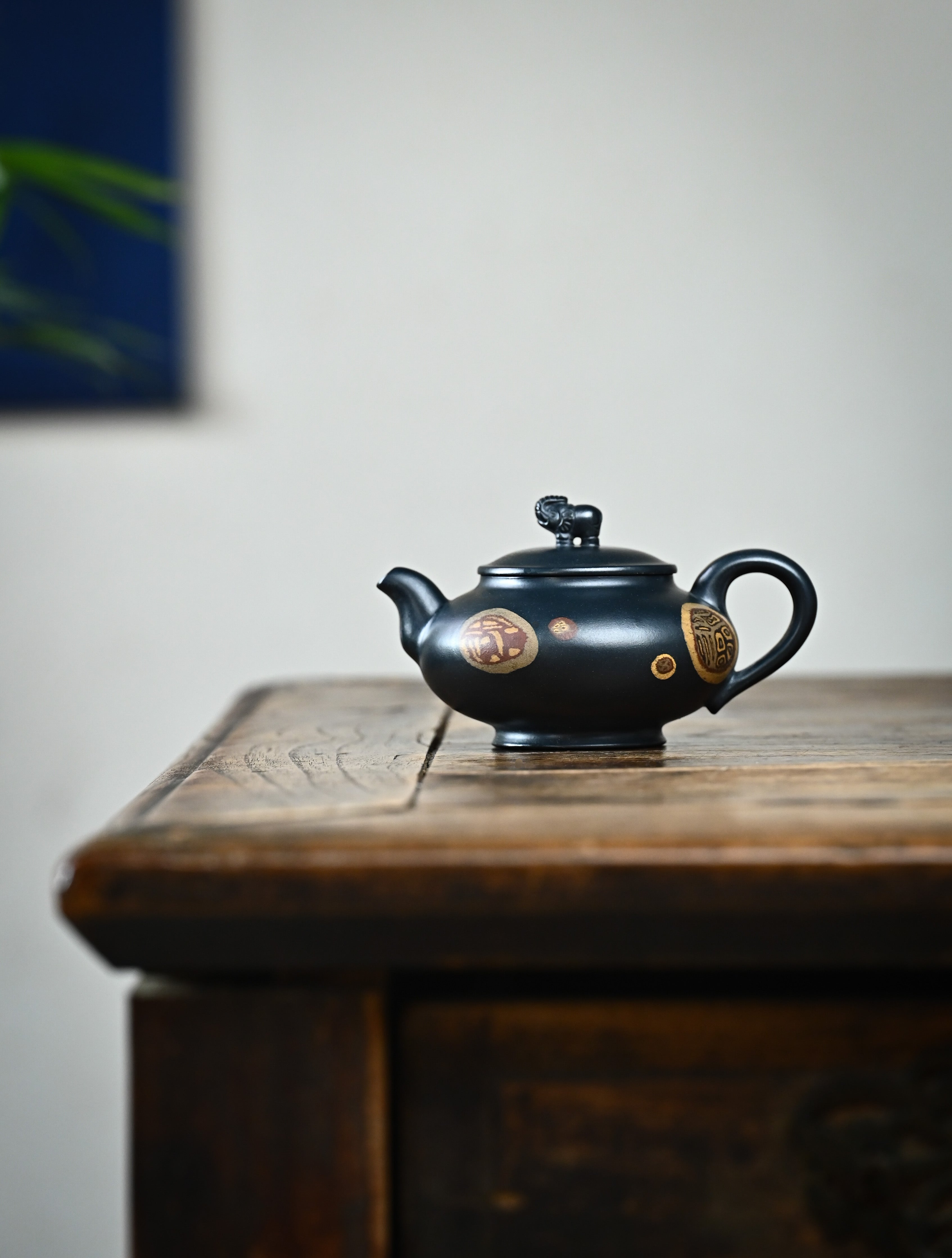 YANYOO handmade Yixing teapot featuring "Que Tou Qing" Lvni clay and Zisha clay blending technique, Si Ping You Xiang, lifestyle wide-angle left side.