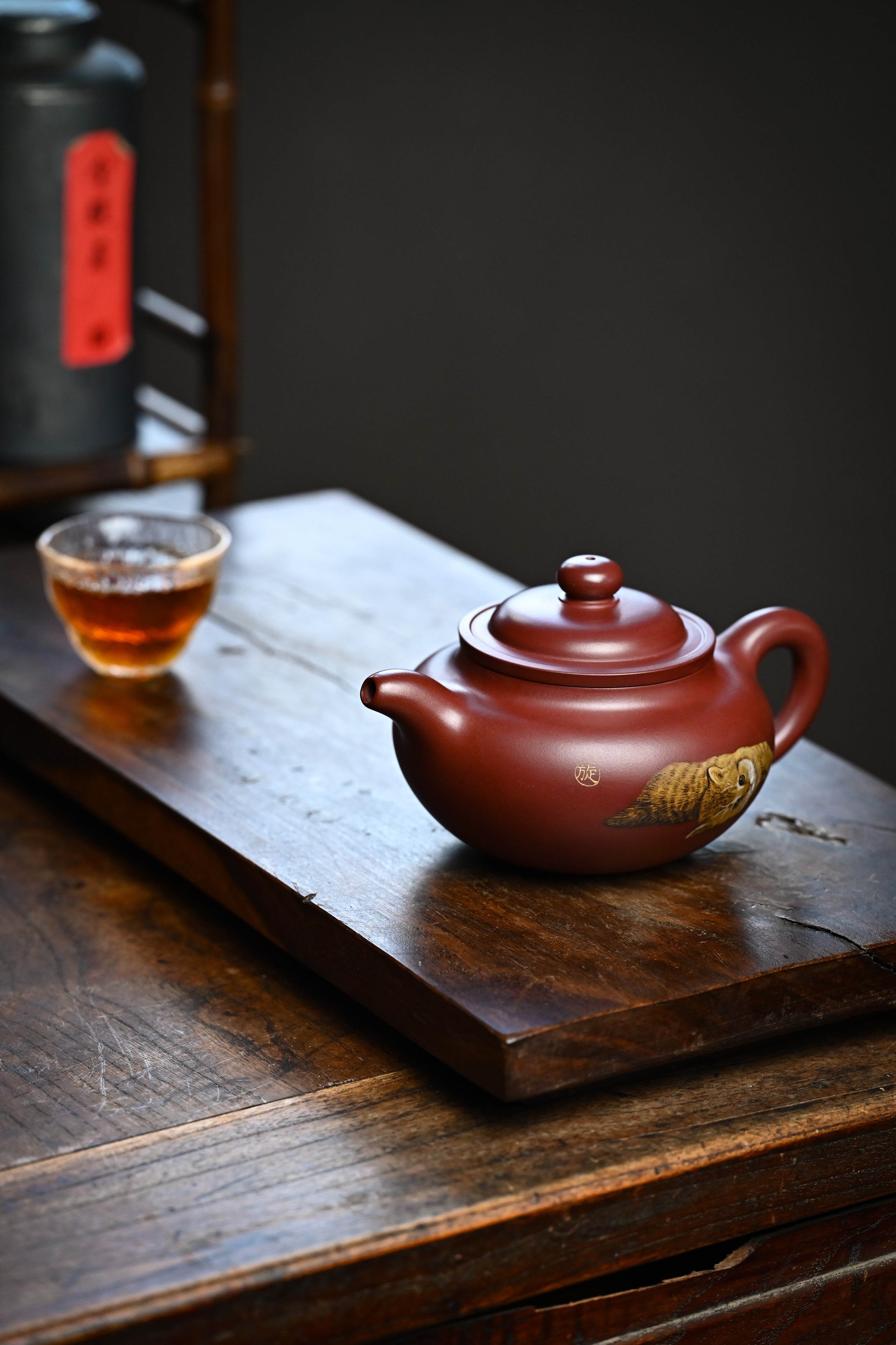 Handmade YANYOO Yixing teapot featuring Hong Pi Long clay and embedded clay painting, lifestyle left side.