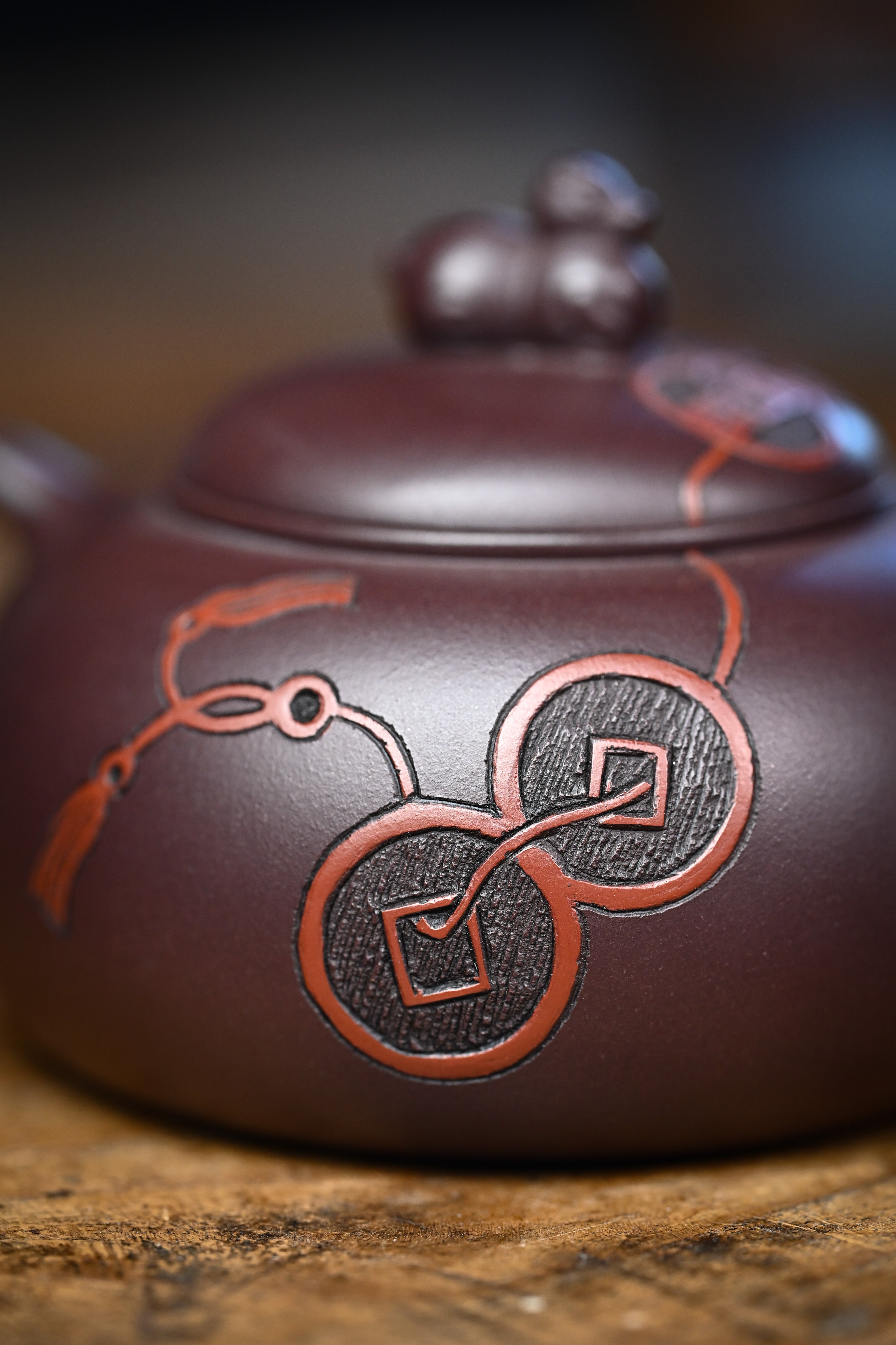 Handmade YANYOO Yixing teapot featuring Zini clay and ancient Chinese Coin sculpture, lifestyle detail.