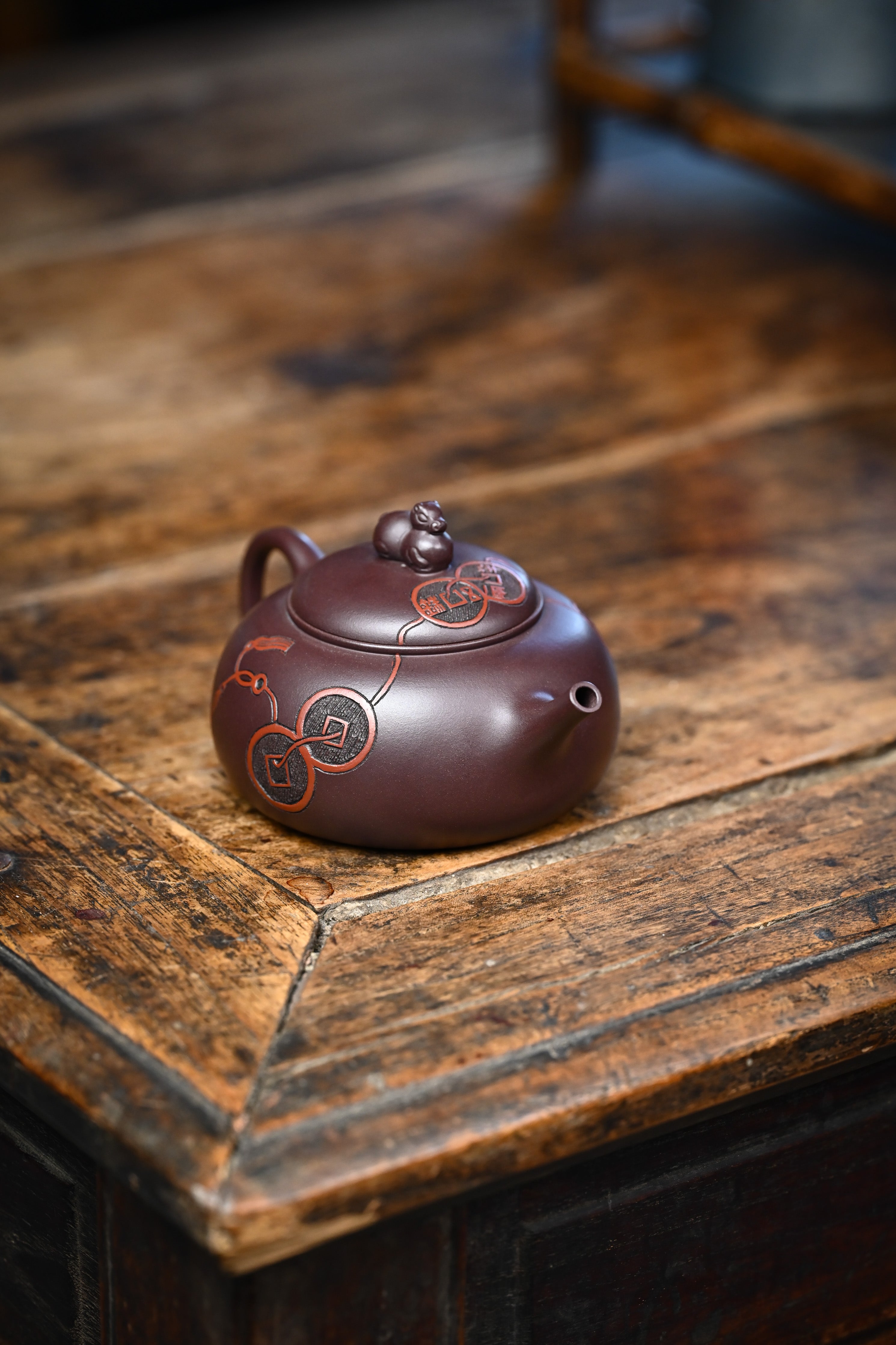 Handmade YANYOO Yixing teapot featuring Zini clay and ancient Chinese Coin sculpture, lifestyle right side.