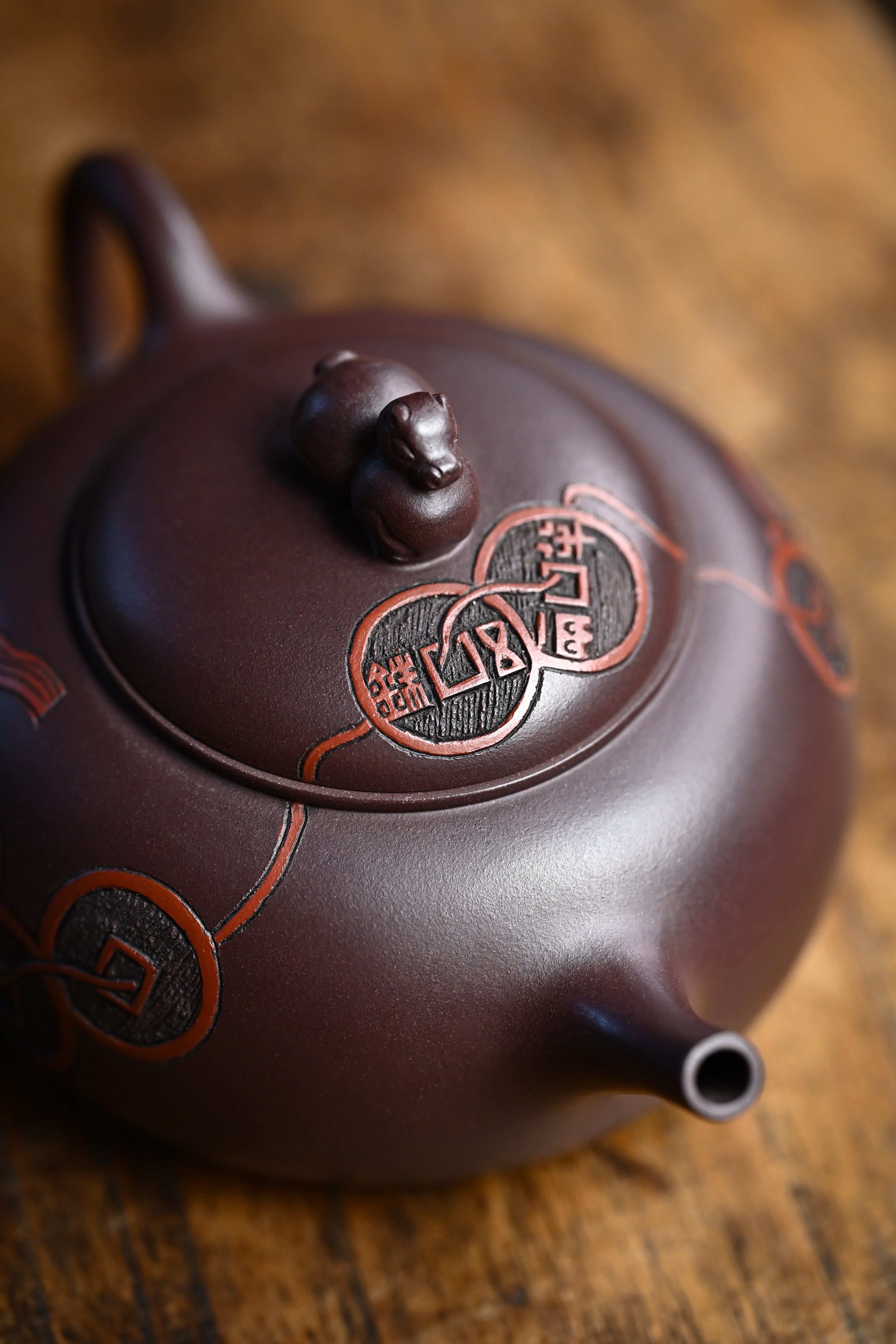 Handmade YANYOO Yixing teapot featuring Zini clay and ancient Chinese Coin sculpture, lifestyle top side.