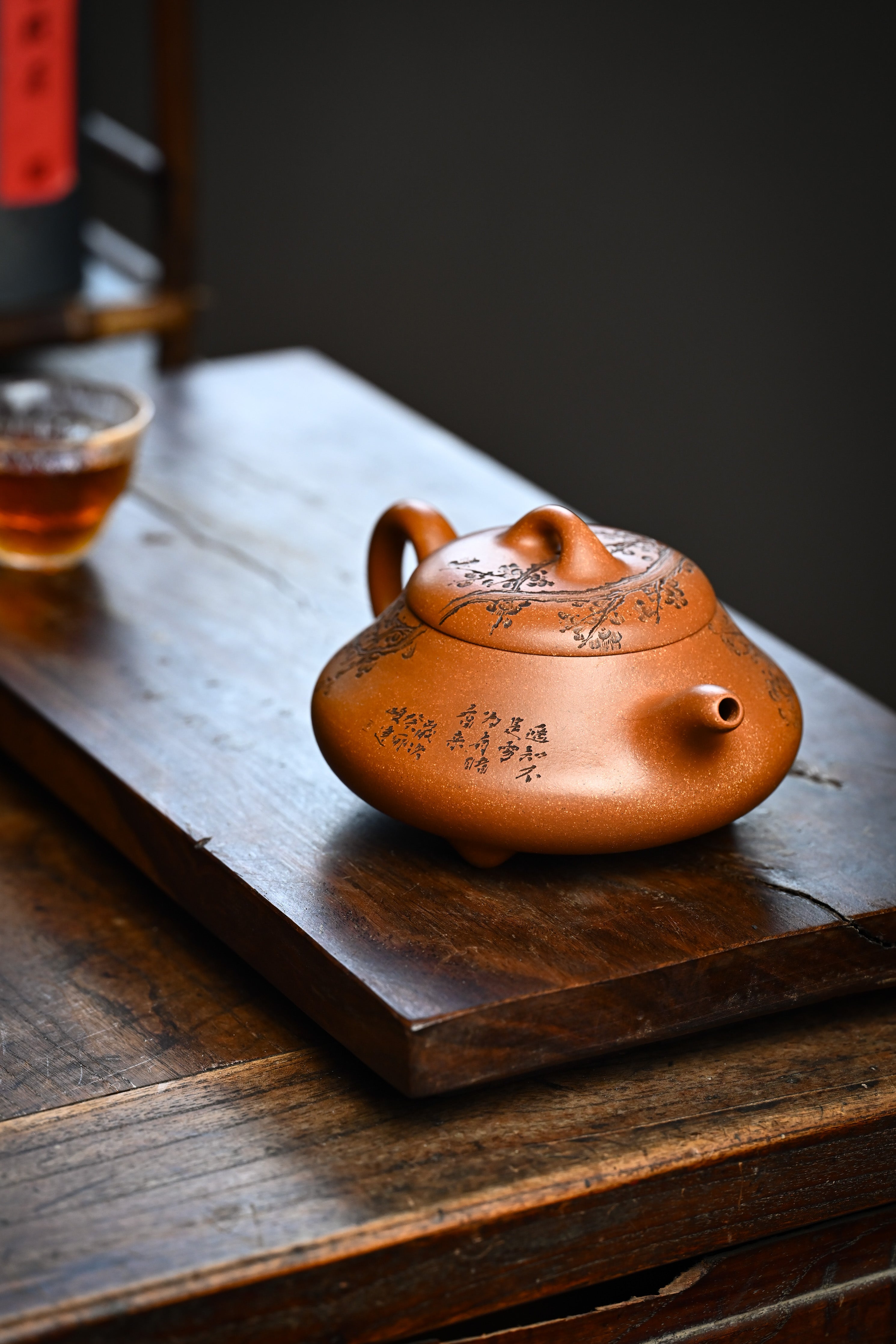 Handmade YANYOO Yixing teapot from Yu Cheng Kiln featuring aged Duanni clay and delicate engraving, lifestyle right side.