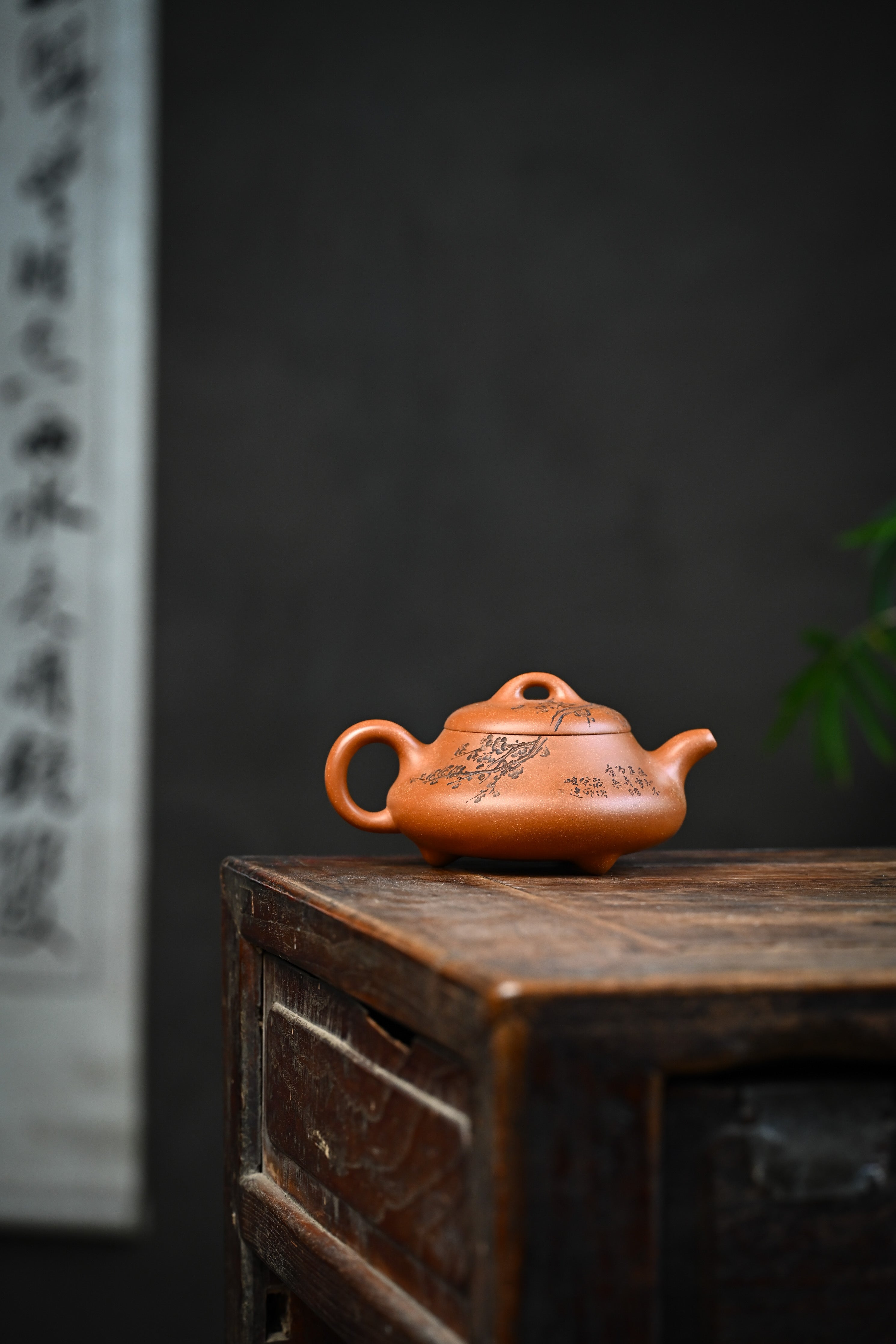 Handmade YANYOO Yixing teapot from Yu Cheng Kiln featuring aged Duanni clay and delicate engraving, lifestyle wide-angle right side.