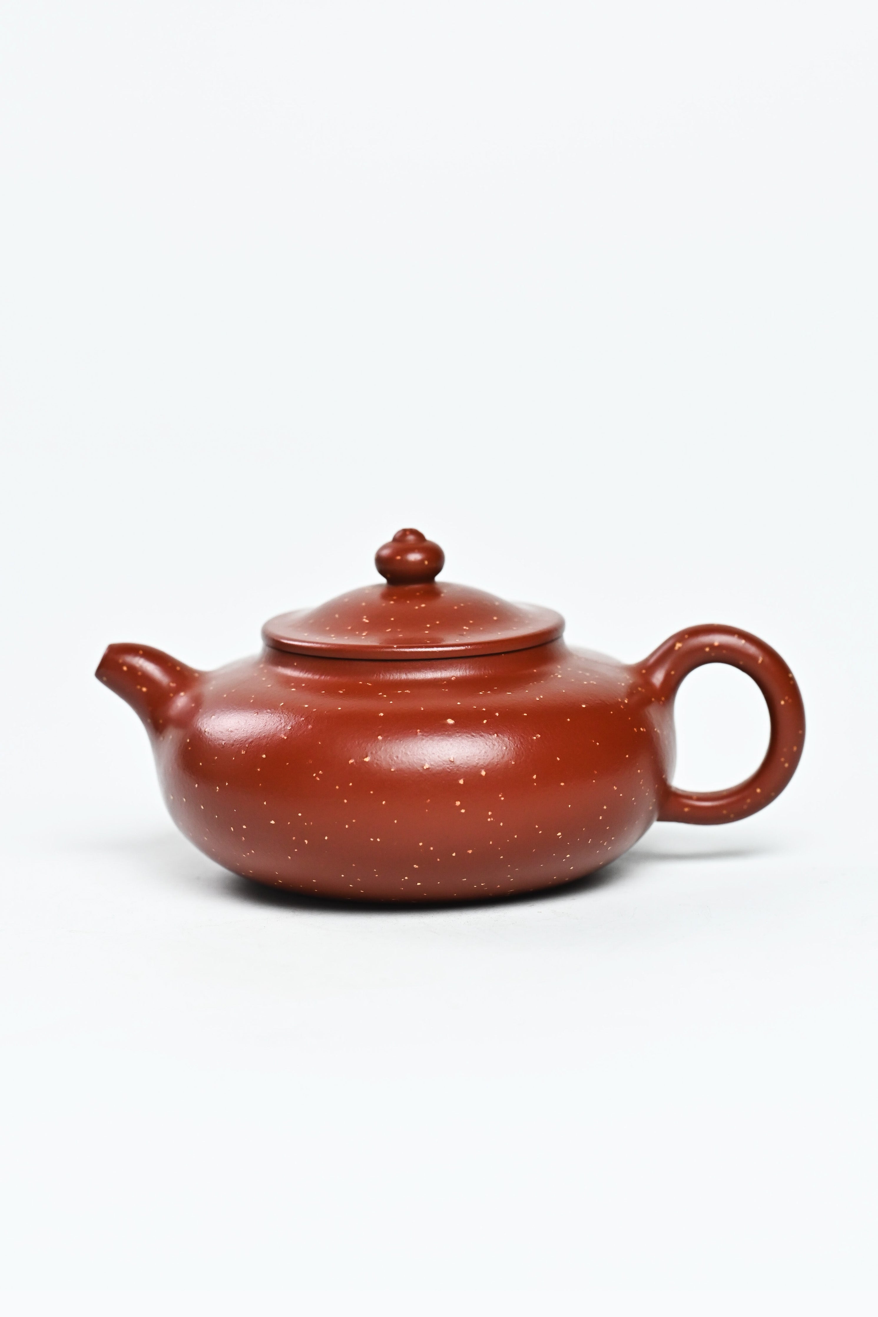 Handmade YANYOO Yixing teapot featuring Zhuni Da Hong Pao clay and sand paving technique, product left side.