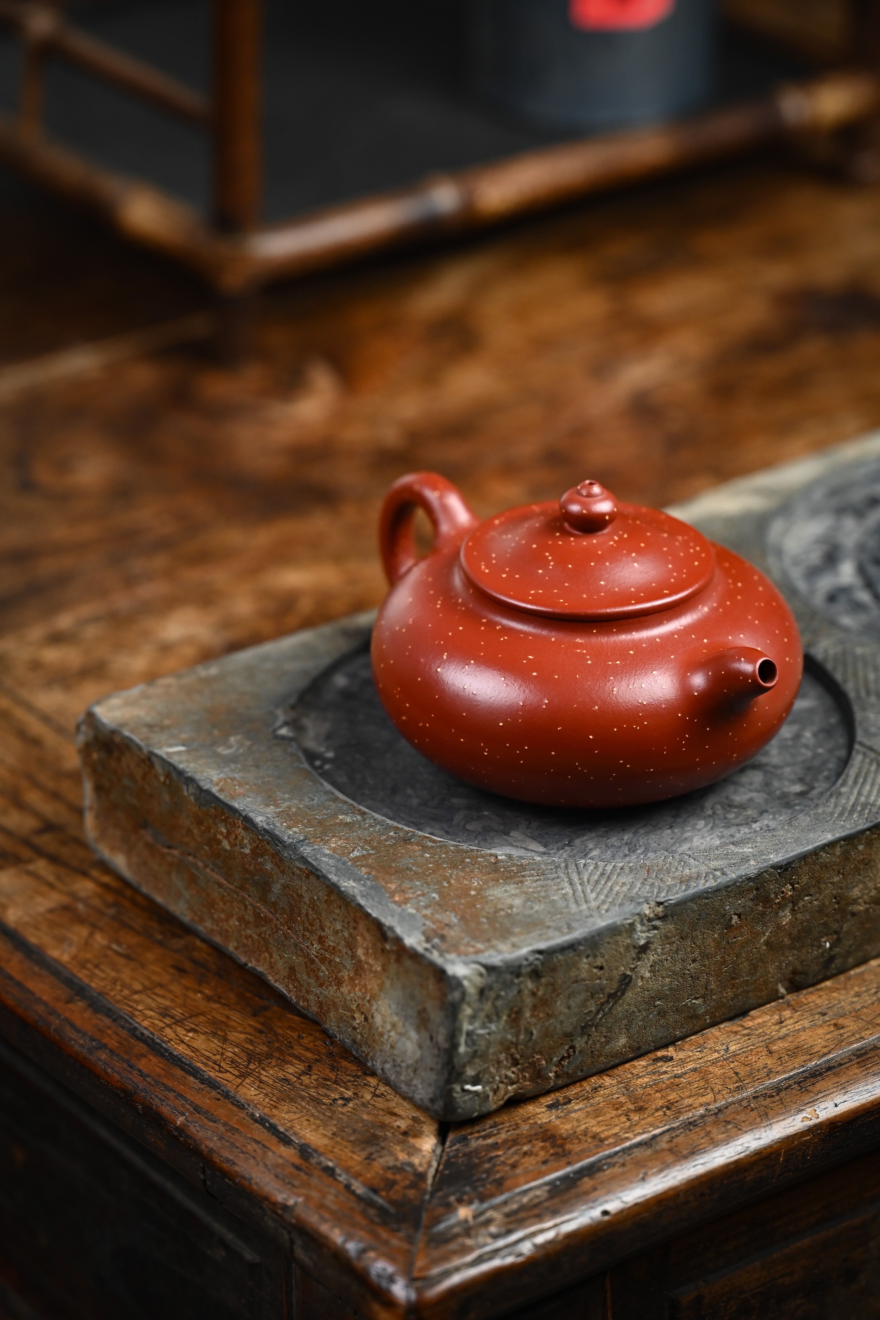 Handmade YANYOO Yixing teapot featuring Zhuni Da Hong Pao clay and sand paving technique, lifestyle right side.