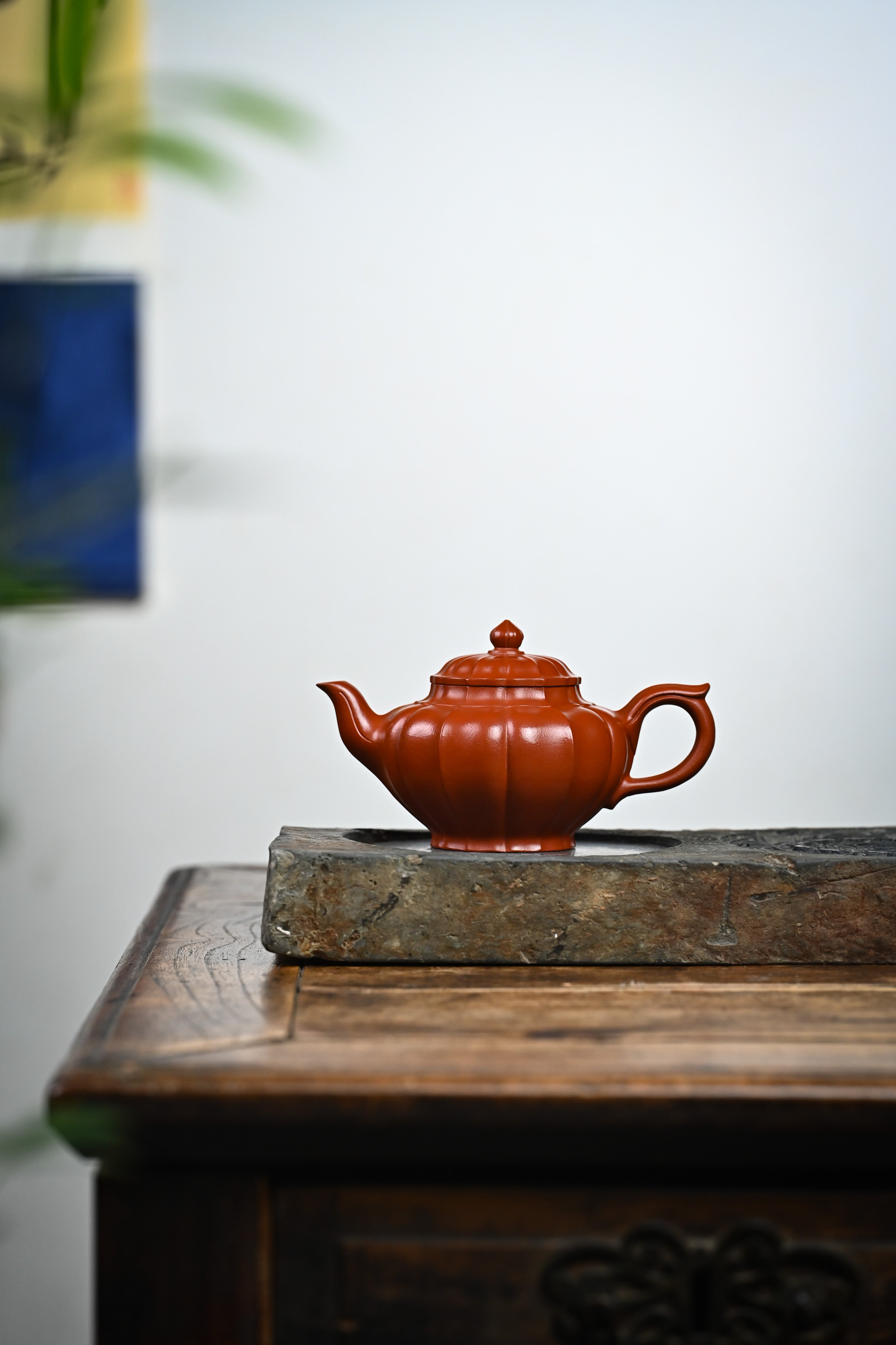 Handmade YANYOO Yixing teapot featuring Zhuni clay and ribbed style, lifestyle wide-angle left side.