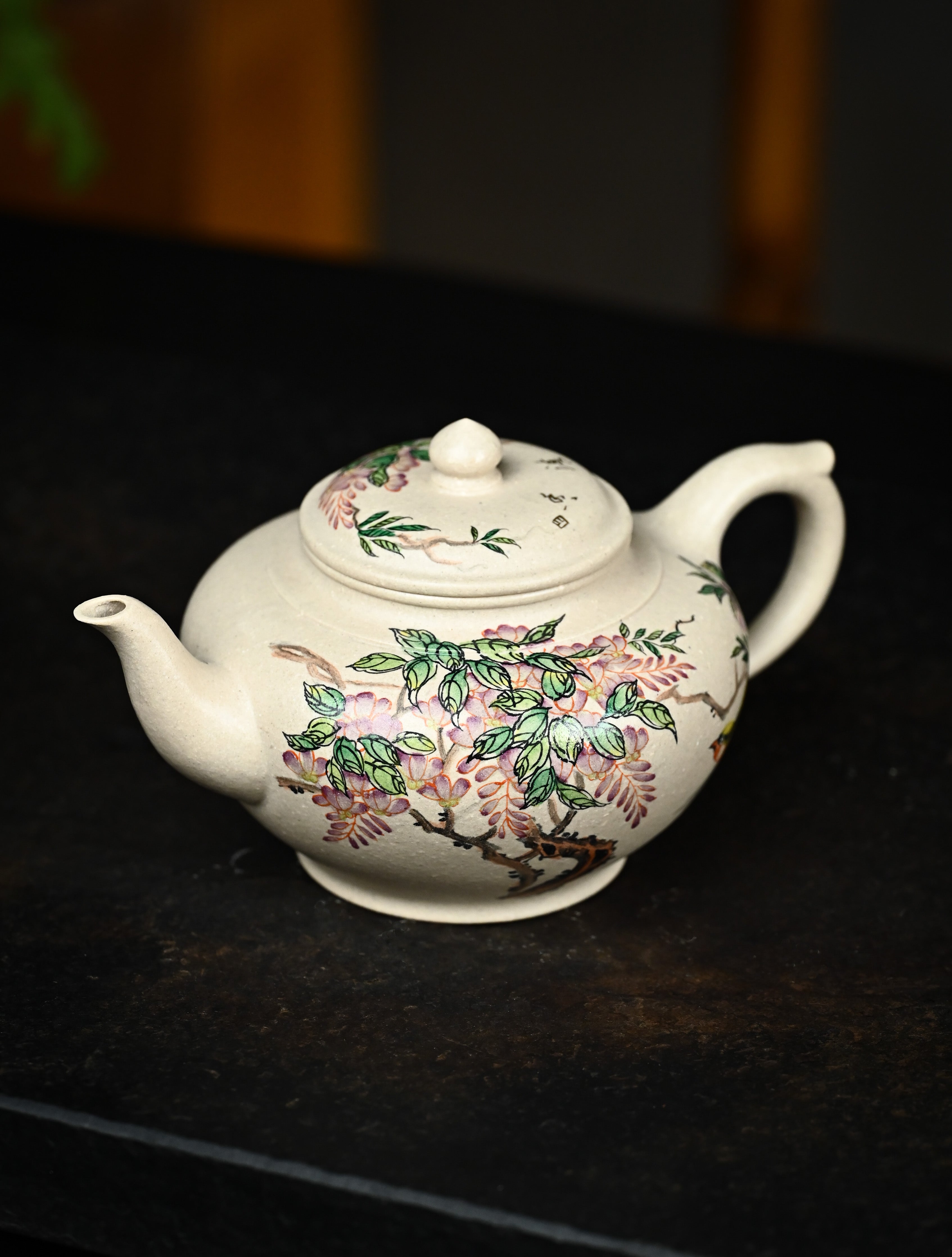 YANYOO handmade Yixing teapot featuring suet white jade Duanni clay and delicate bird-and-peach themed clay painting, Xiao Ying, lifestyle left side.