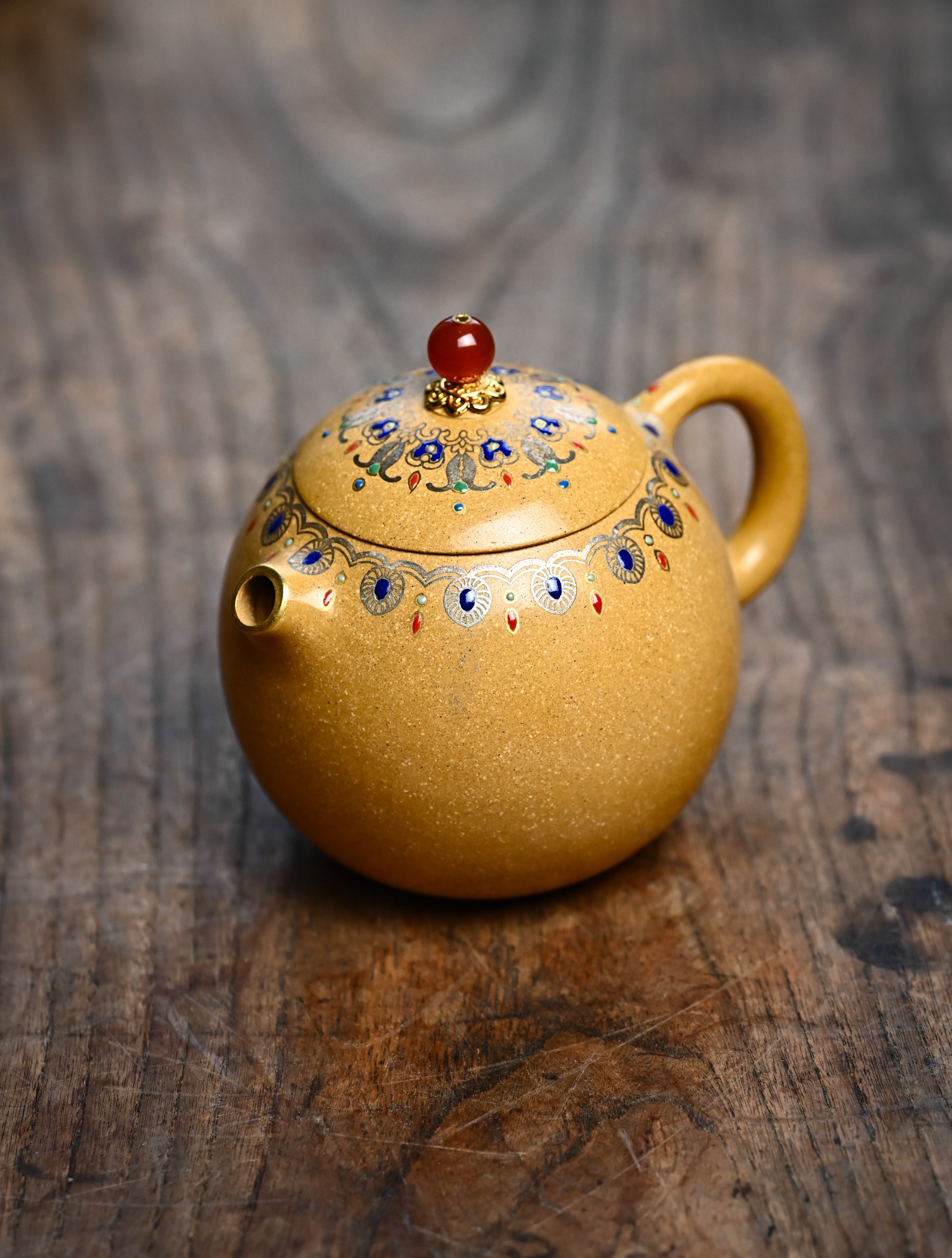 YANYOO handmade Yixing teapot featuring Duanni clay, water polish technique (Shuimo) and delicate Falangcai, Long Dan, lifestyle left side.