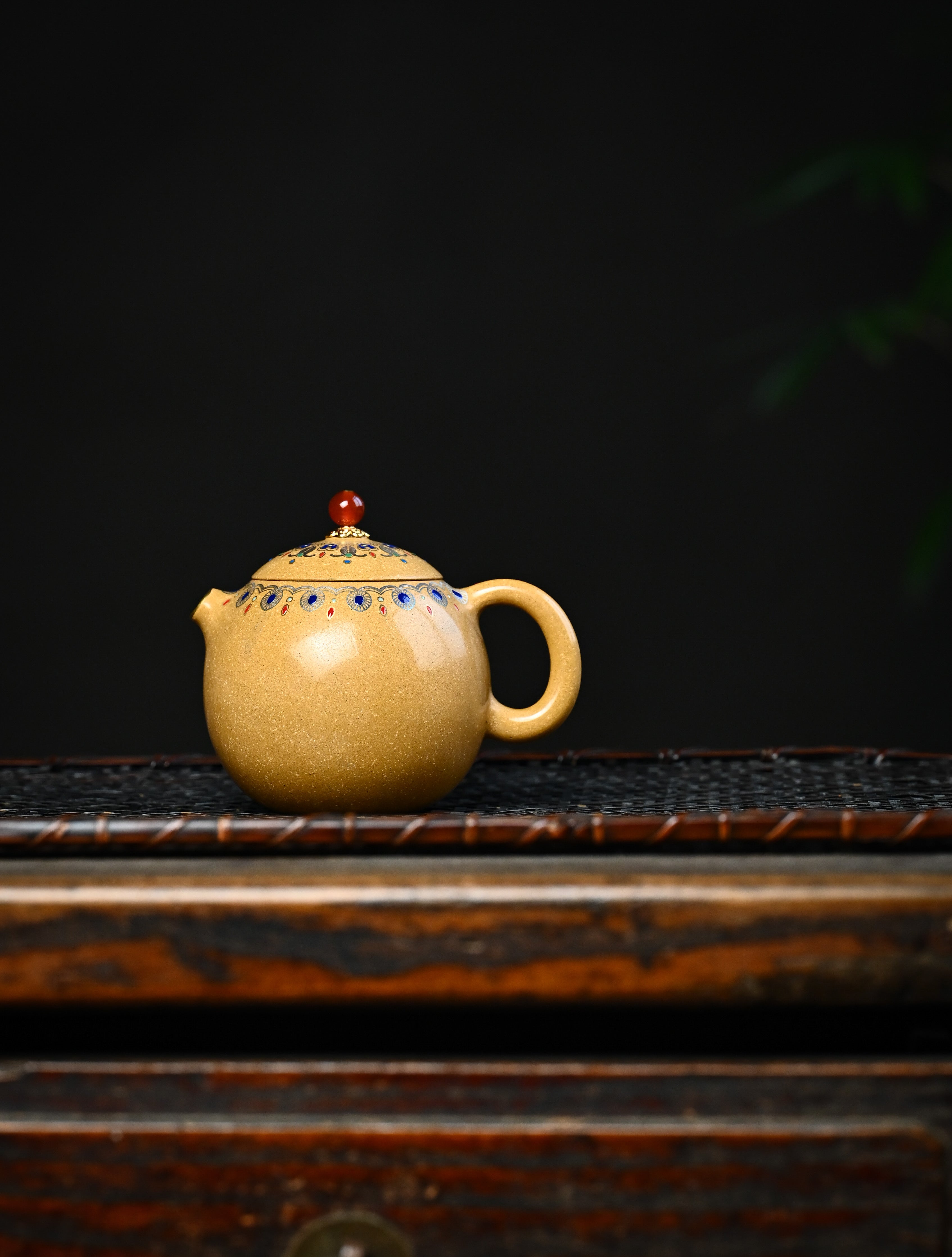 YANYOO handmade Yixing teapot featuring Duanni clay, water polish technique (Shuimo) and delicate Falangcai, Long Dan, lifestyle wide-angle left side.