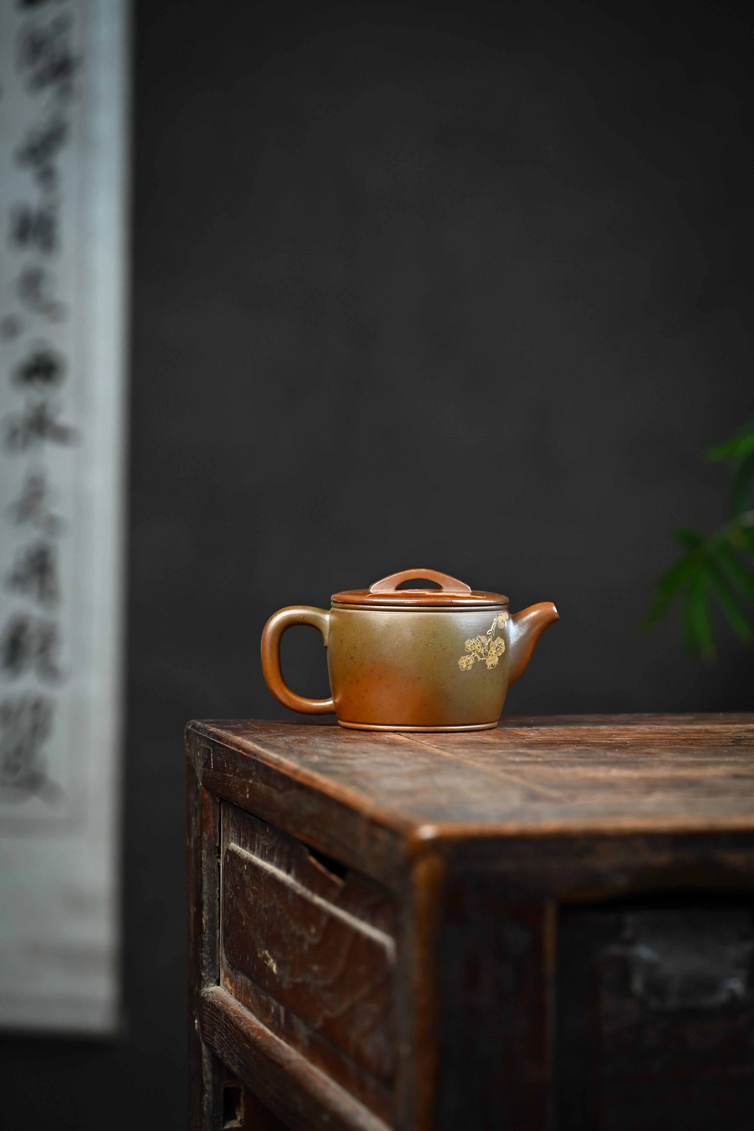 Handmade YANYOO Yixing teapot featuring hand-painted crane and gold enamel, lifestyle wide-angle right side.