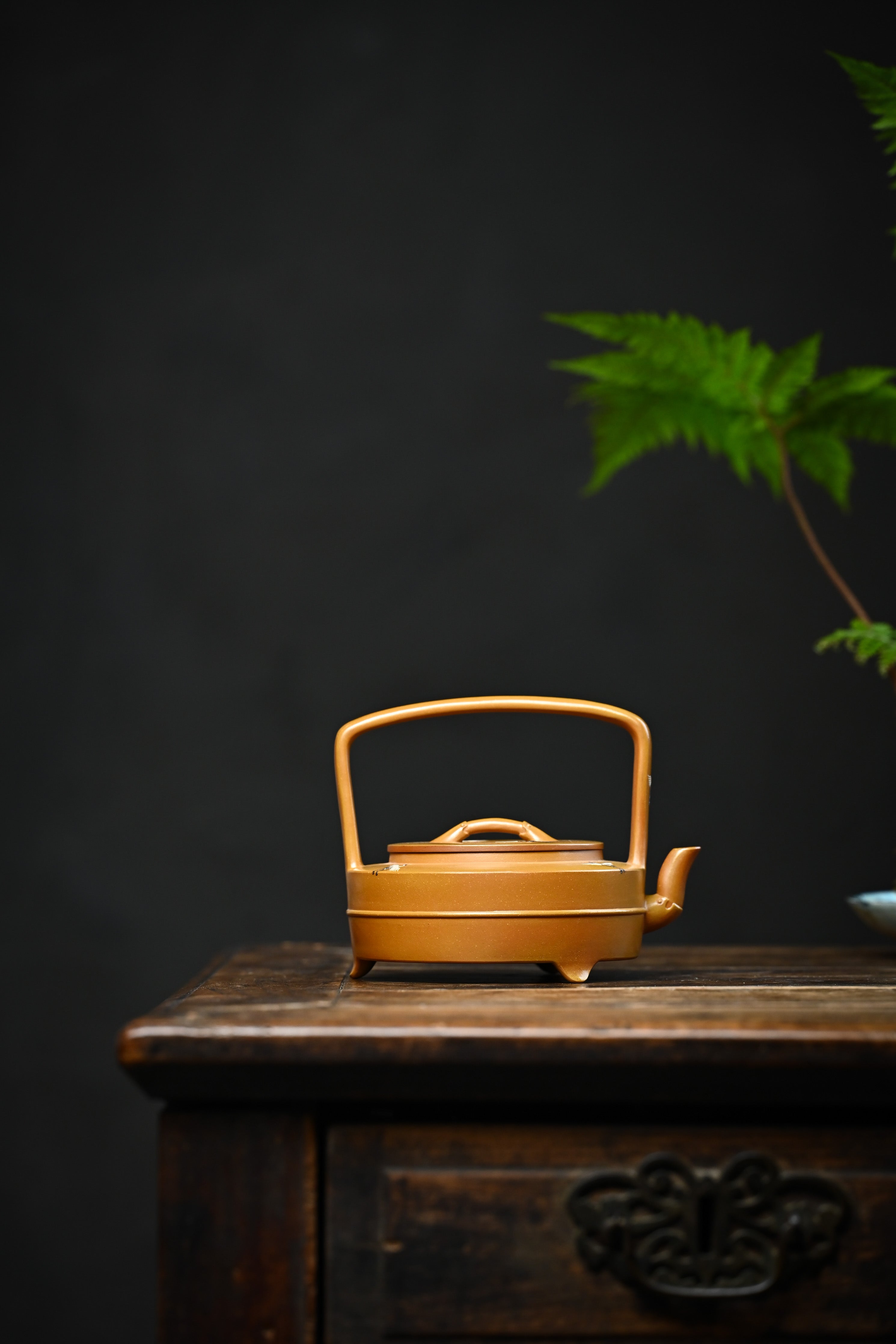 Handmade YANYOO Yixing teapot featuring hand-painted cloud-and-crane motif, lifestyle wide-angle right side.