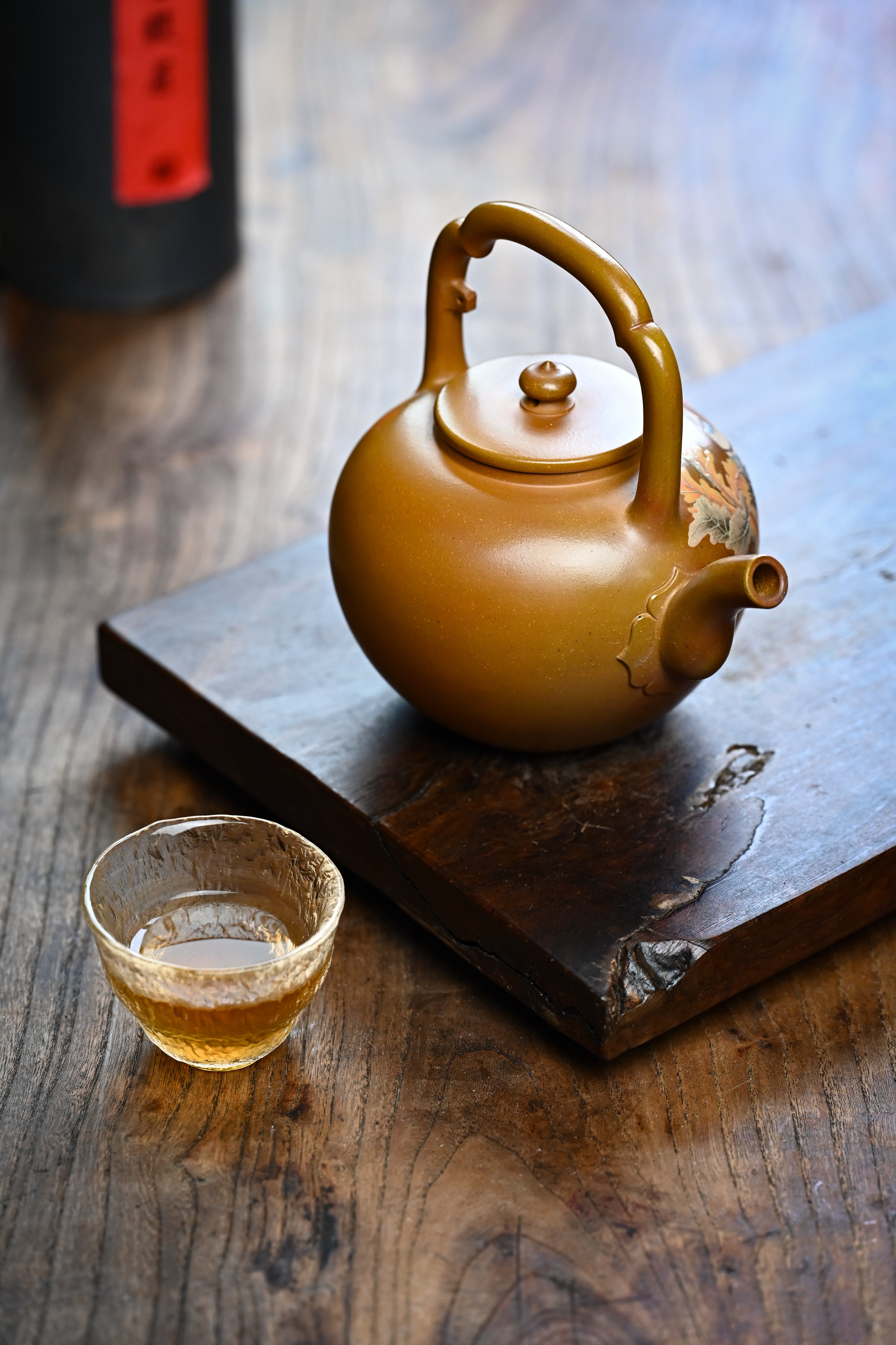 Handmade YANYOO Yixing teapot featuring hand-painted floral and bird motif, lifestyle right side.