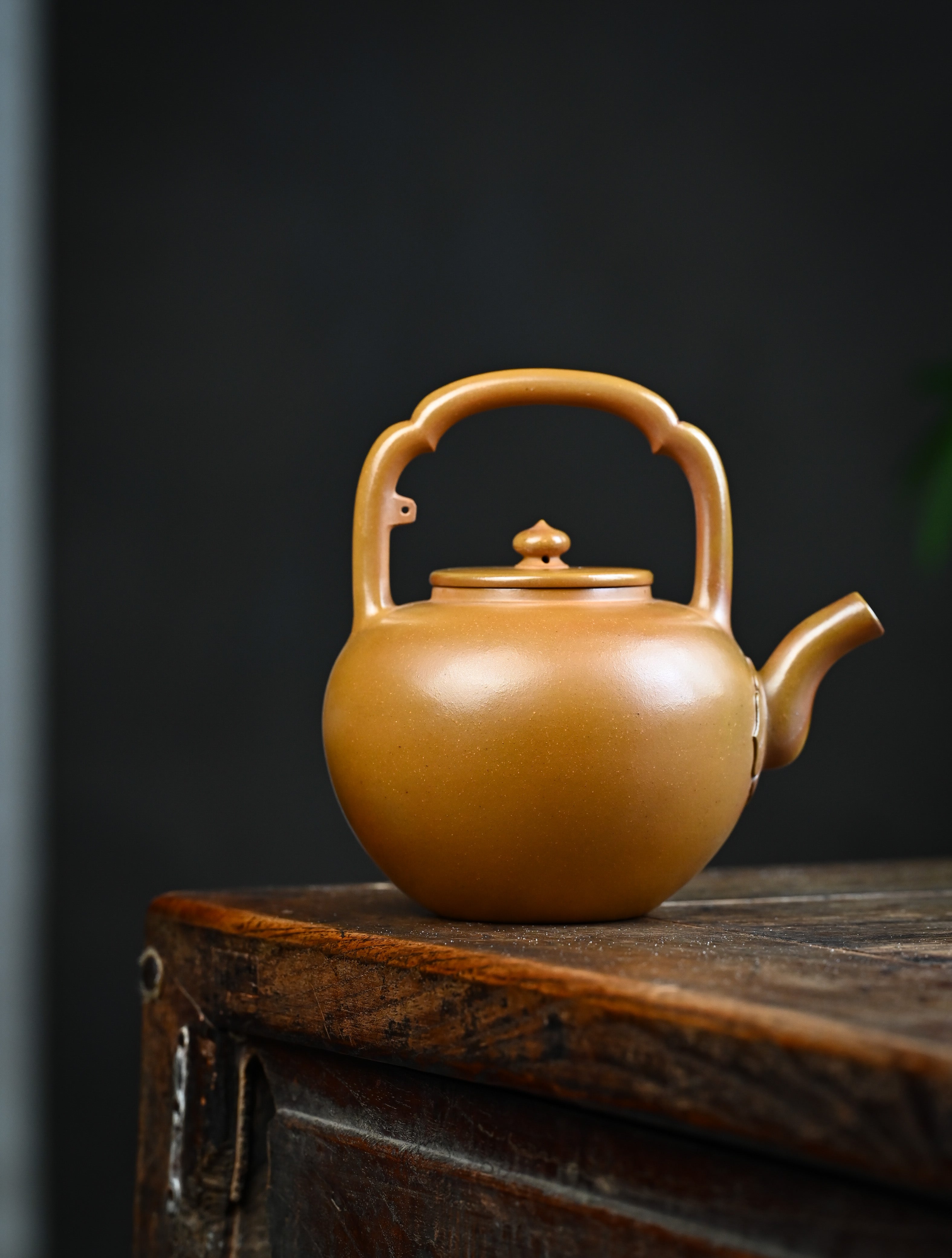 YANYOO handmade wood-fired Yixing teapot featuring hand-painted floral-and-bird motif and lifting handle, lifestyle wide-angle right side.