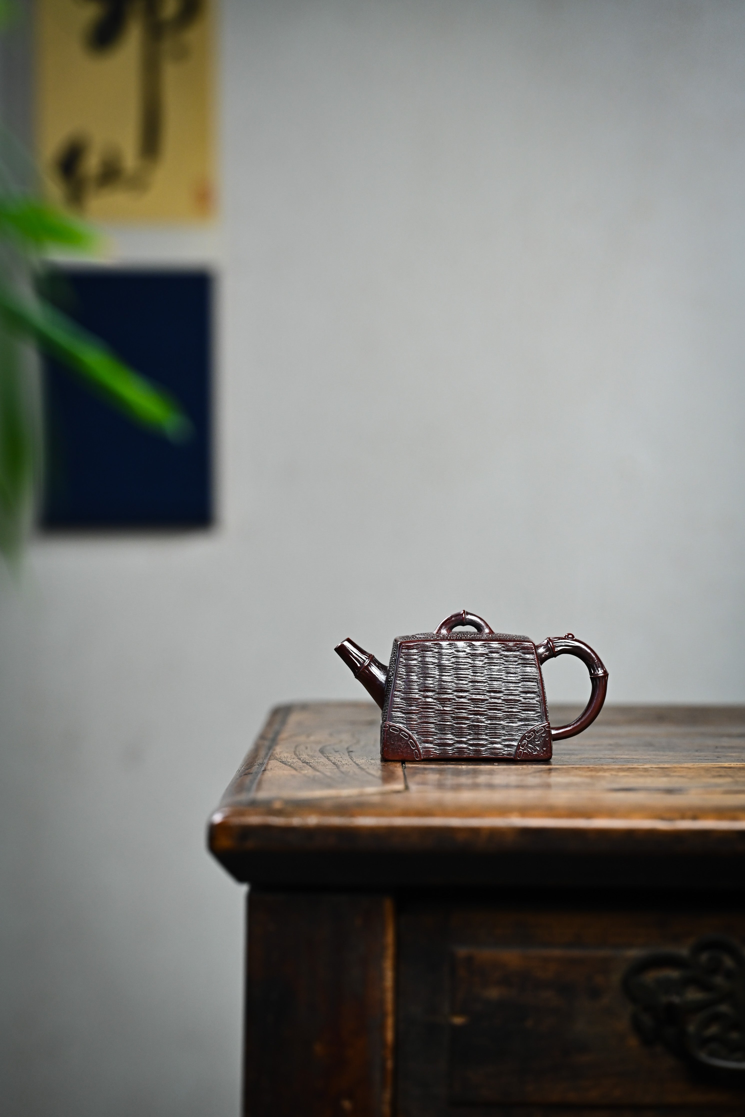 Handcrafted YANYOO Yixing teapot featuring aged Wuni clay and bamboo weaving technique, lifestyle wide-angle left side.