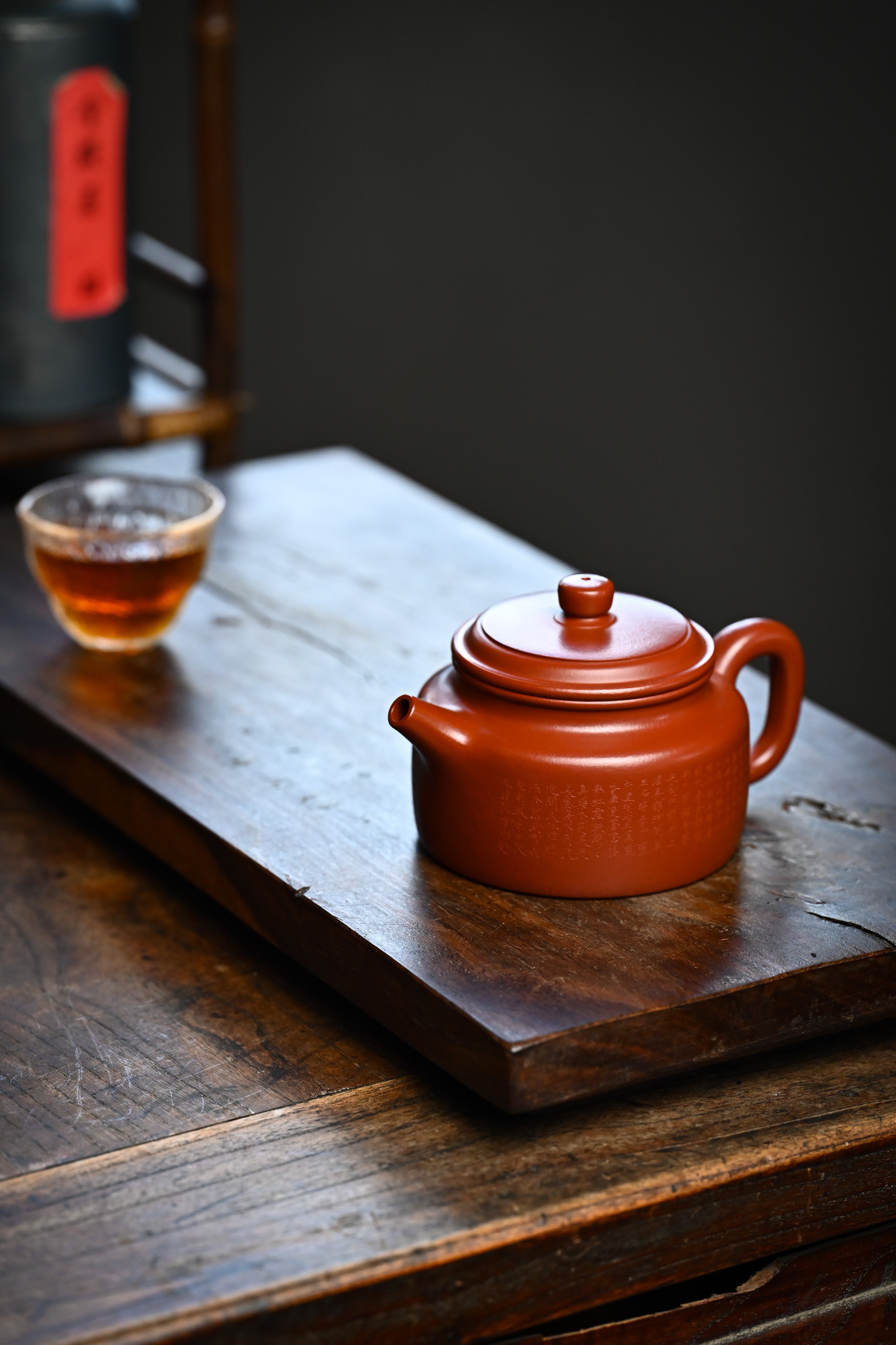 Handmade YANYOO Yixing teapot featuring Zhuni clay and Chinese landscape engraving, lifestyle left side.