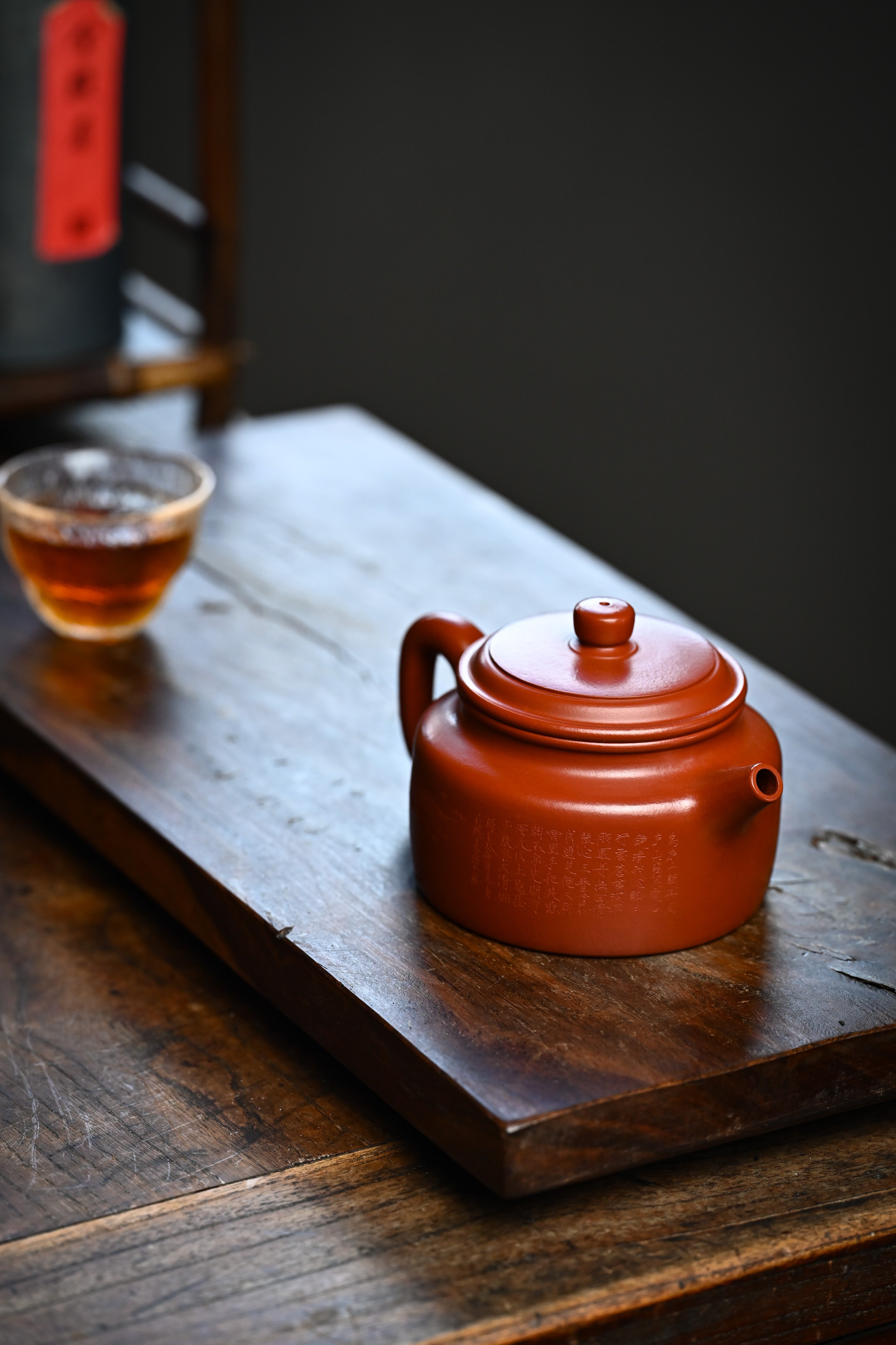 Handmade YANYOO Yixing teapot featuring Zhuni clay and Chinese landscape engraving, lifestyle detail right side.