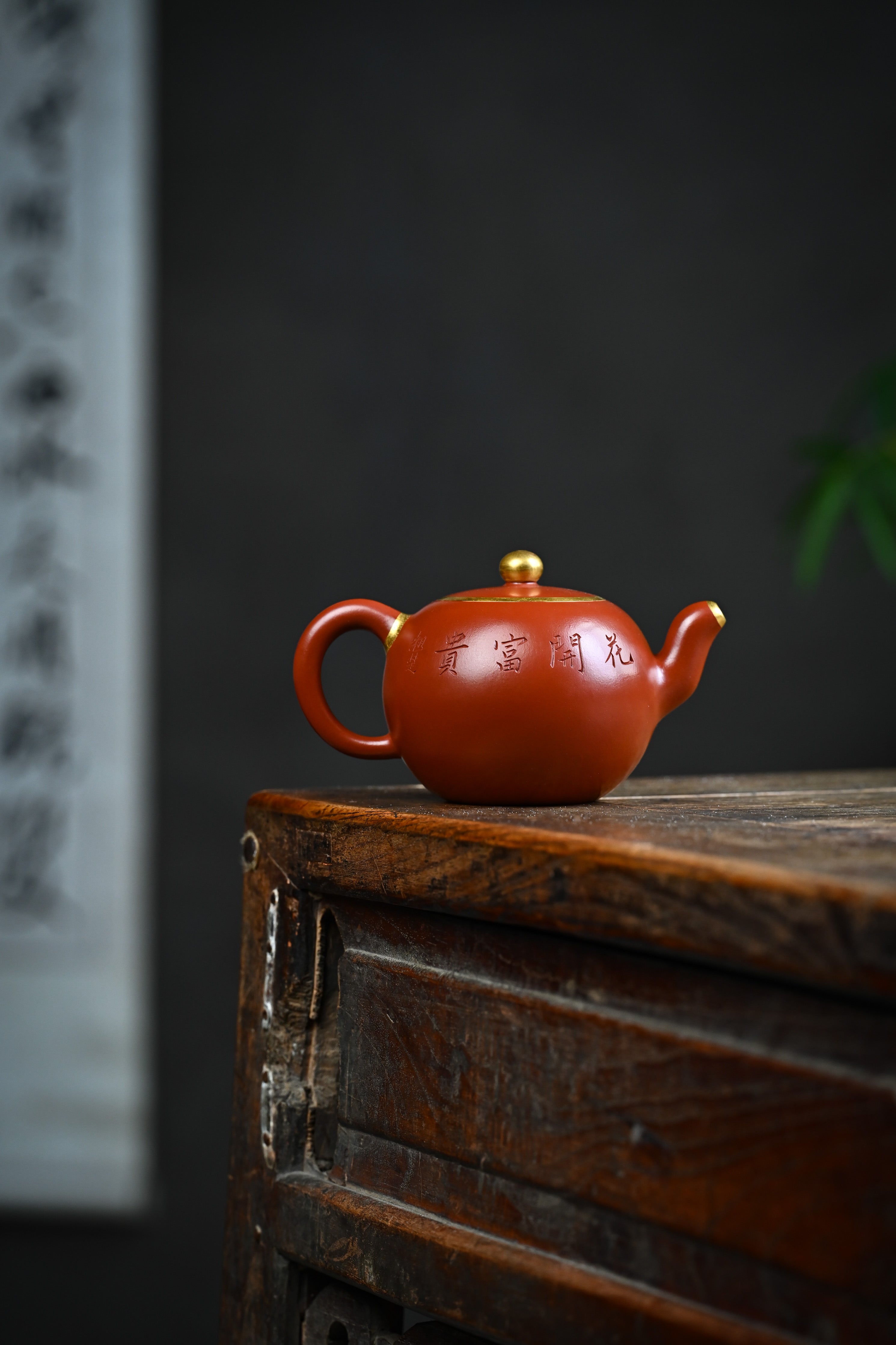 Handmade YANYOO Yixing teapot featuring Zhuni clay and relief engraving, lifestyle wide-angle right side.