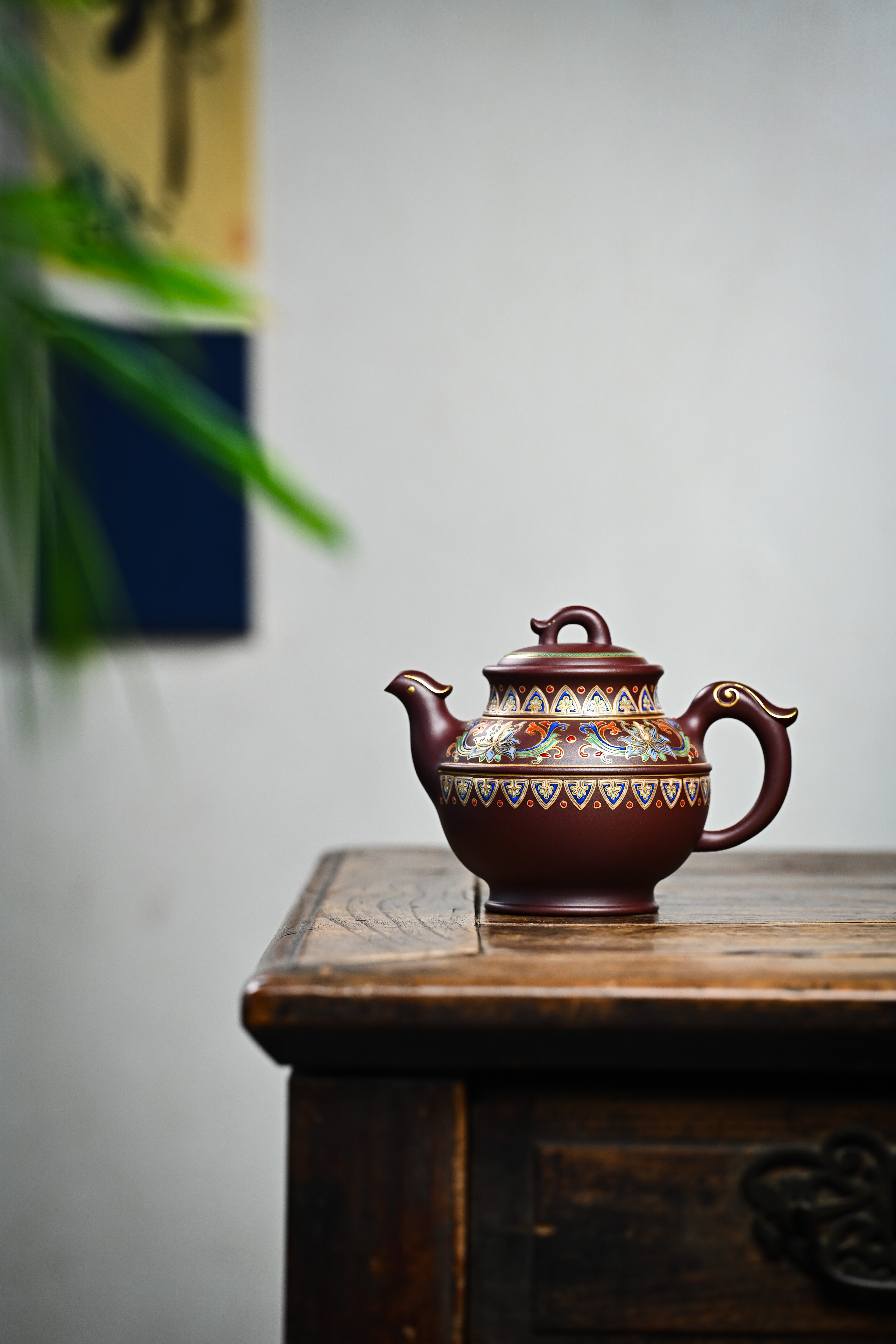 Handmade YANYOO Yixing teapot featuring purple clay and Falangcai lotus-themed design, lifestyle wide-angle left side.