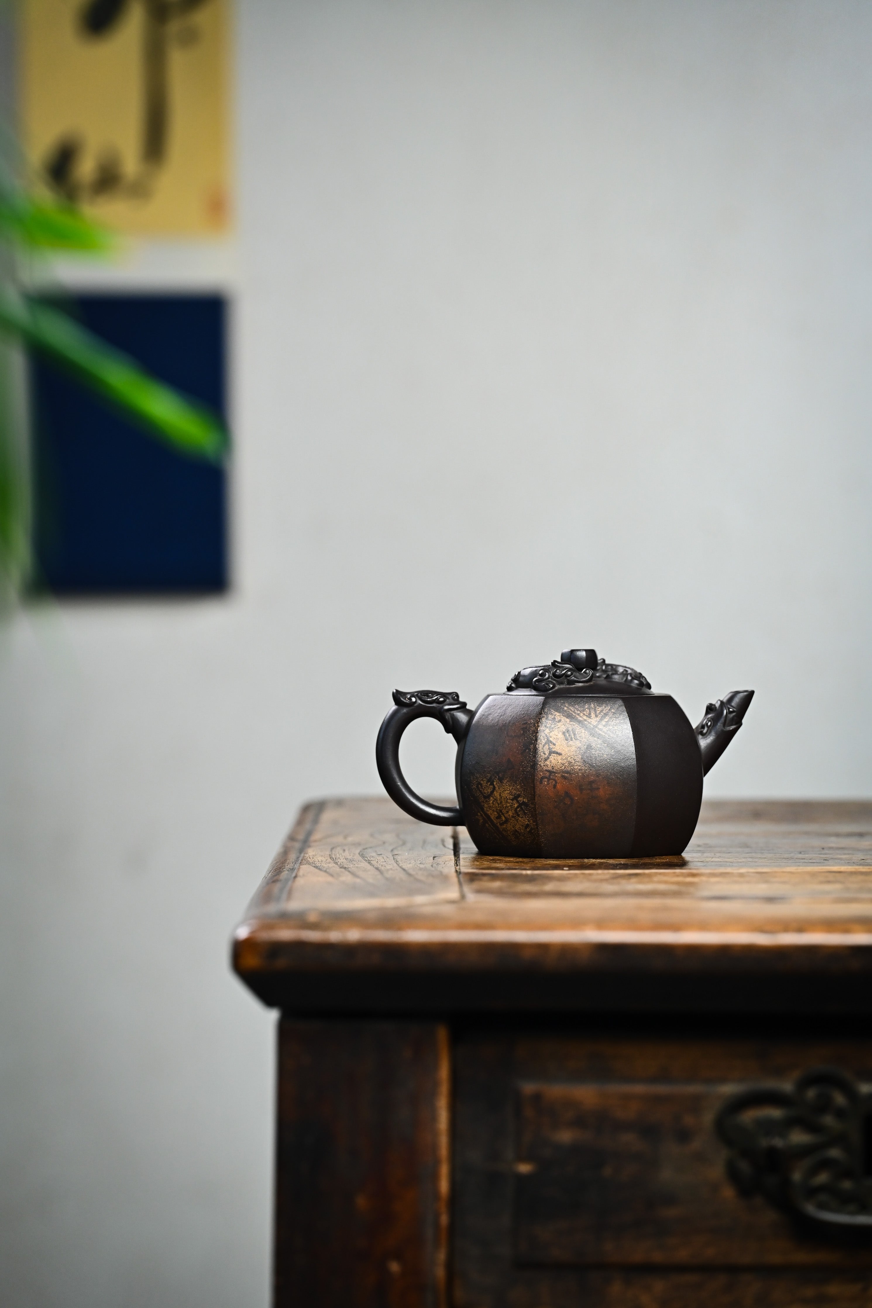 Handmade YANYOO Yixing teapot featuring aged Celadon clay and Oracle Bone scripts pattern, lifestyle wide-angle right side.