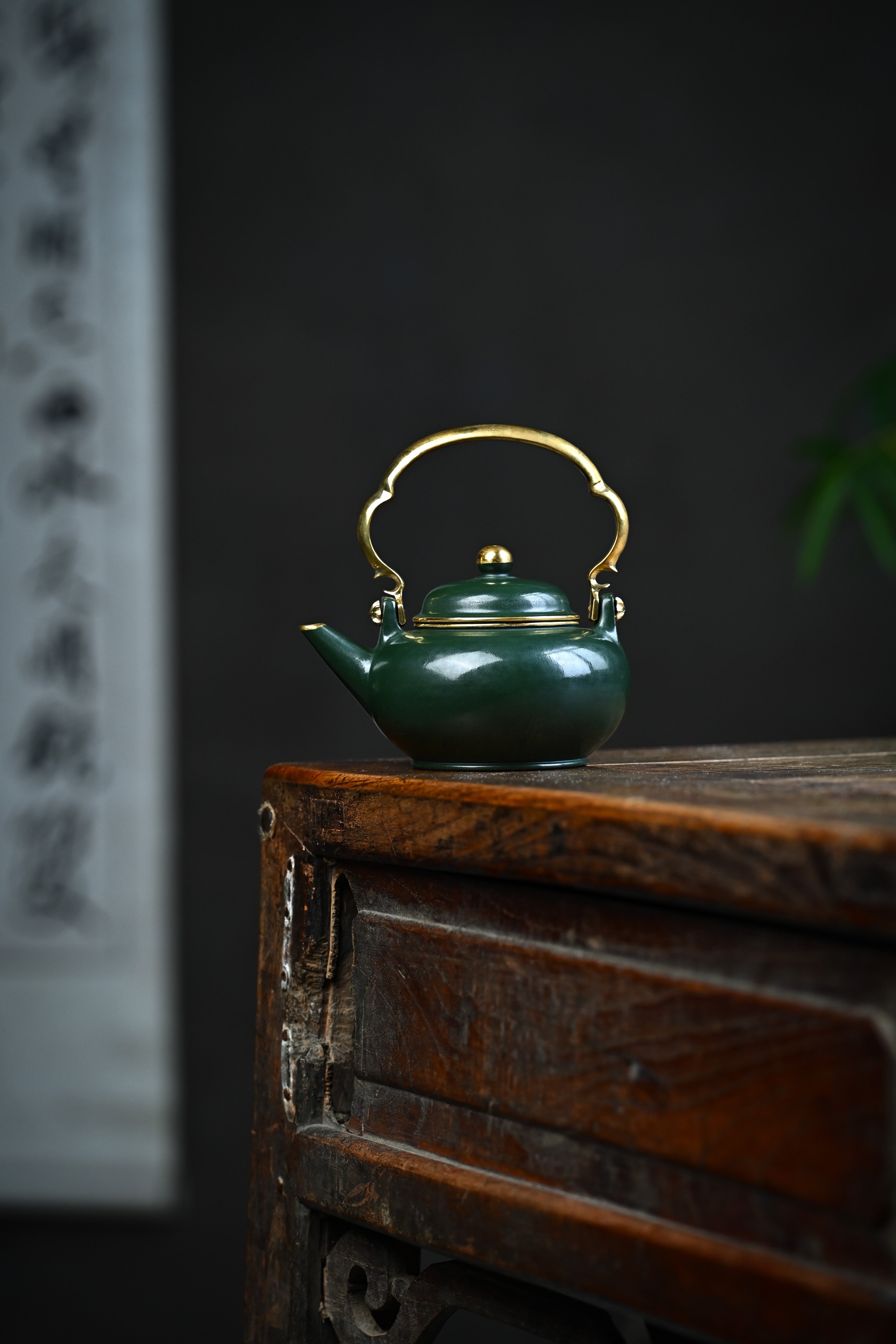 Handmade YANYOO Yixing teapot featuring Lvni clay and water-polished craftsmanship, lifestyle wide-angle left side.