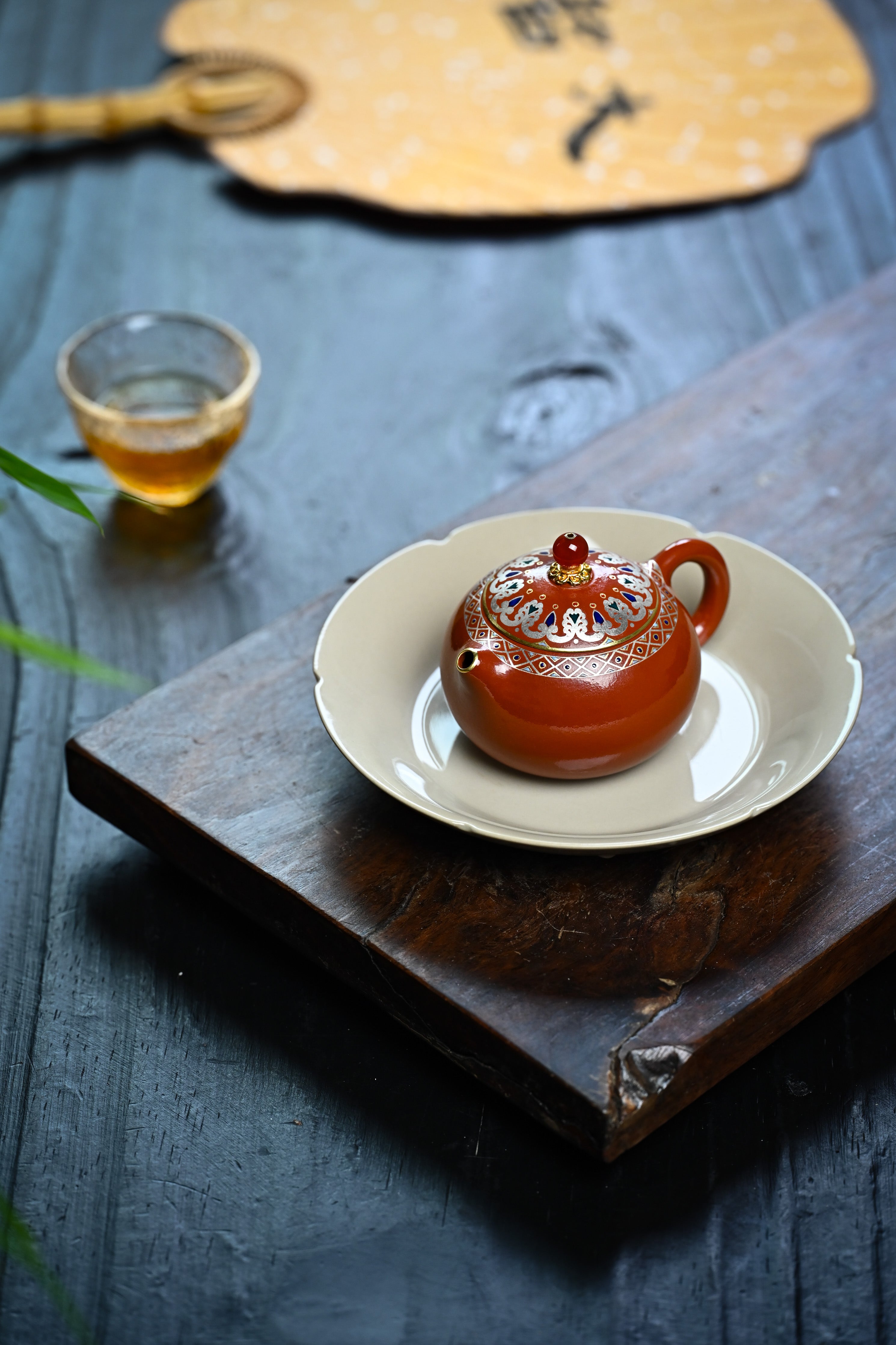 Handmade YANYOO Yixing teapot featuring Zhuni clay, Falangcai and water-polished craftsmanship, lifestyle left side.