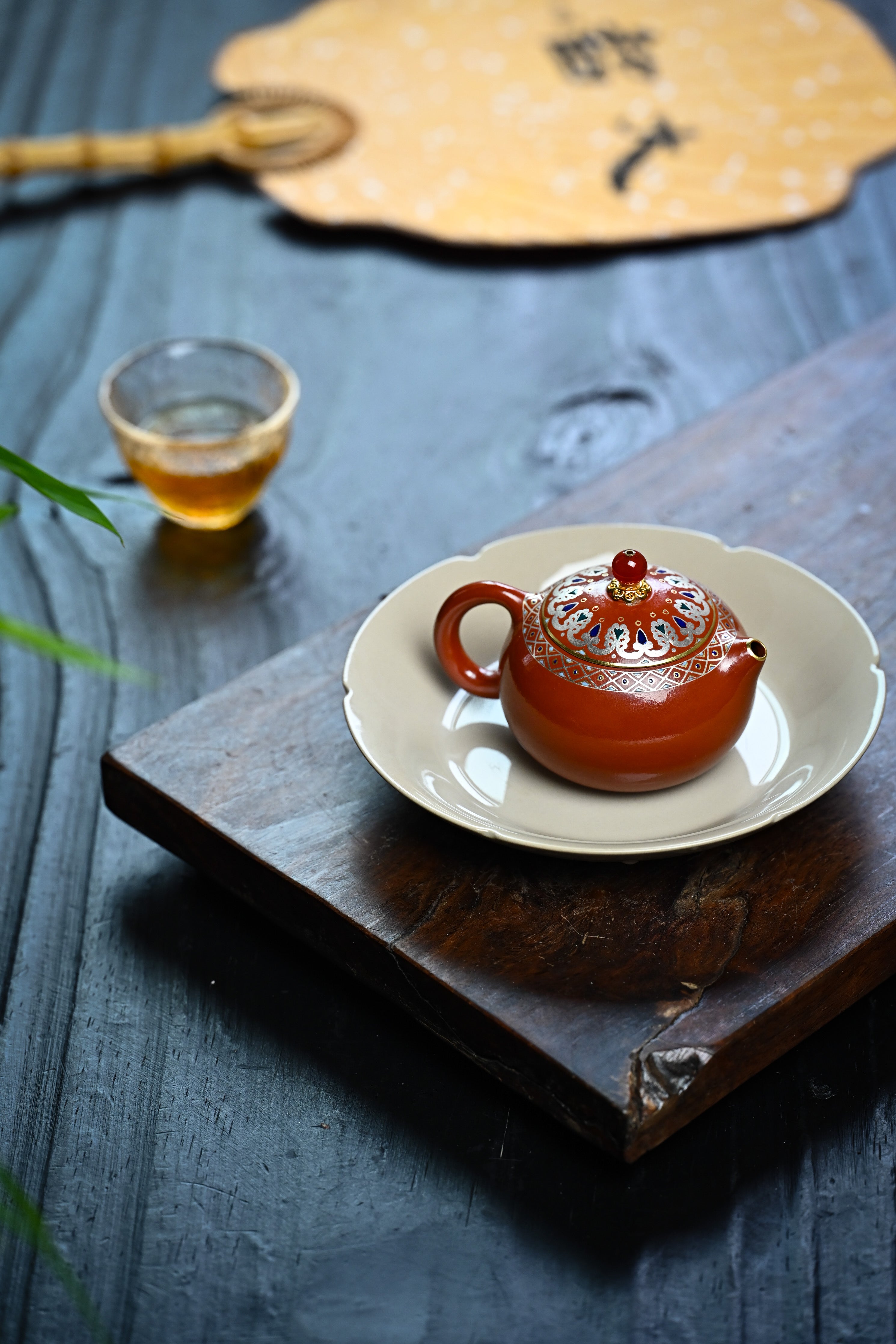 Handmade YANYOO Yixing teapot featuring Zhuni clay, Falangcai and water-polished craftsmanship, lifestyle right side.