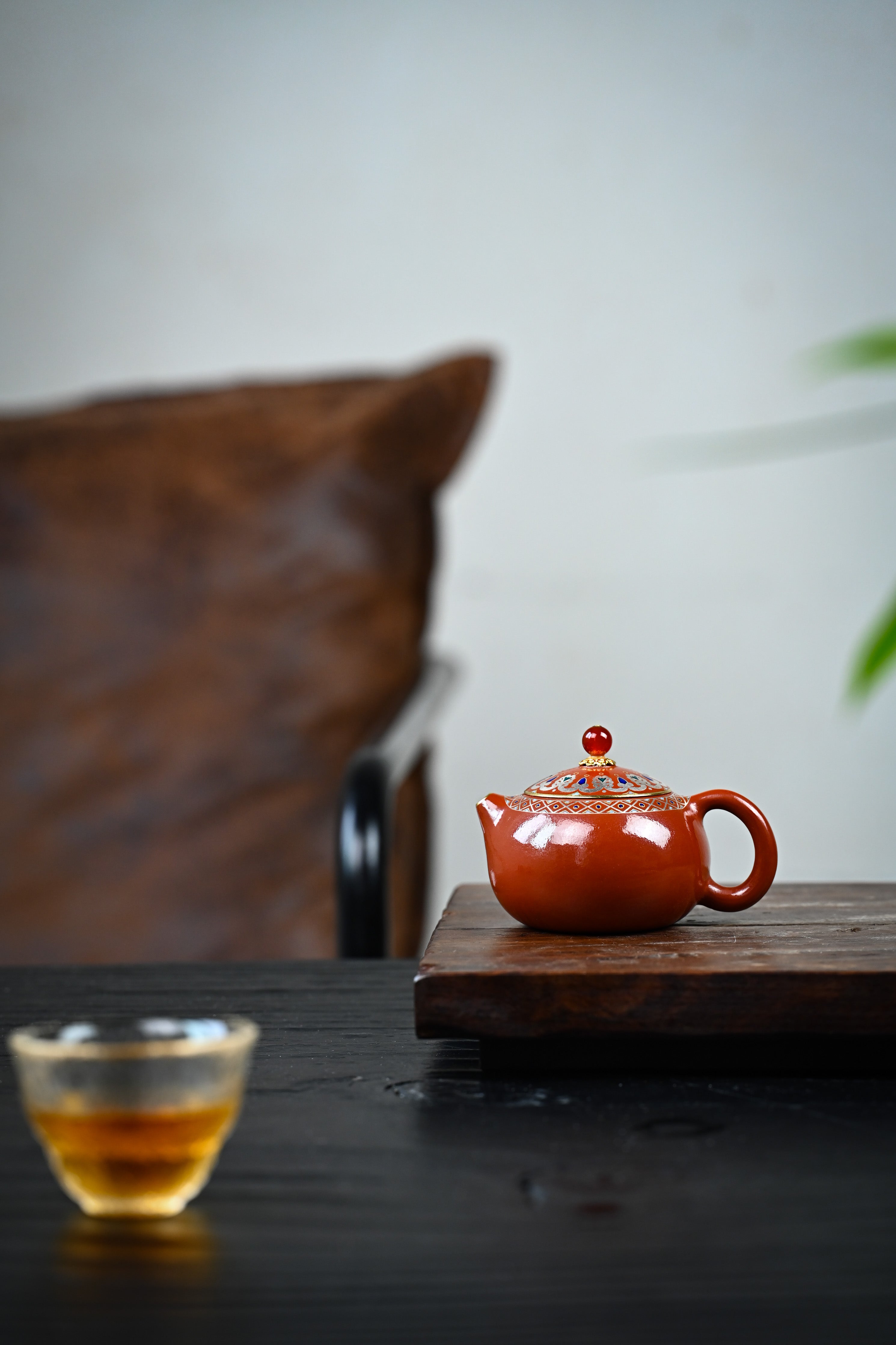 Handmade YANYOO Yixing teapot featuring Zhuni clay, Falangcai and water-polished craftsmanship, lifestyle wide-angle left side.