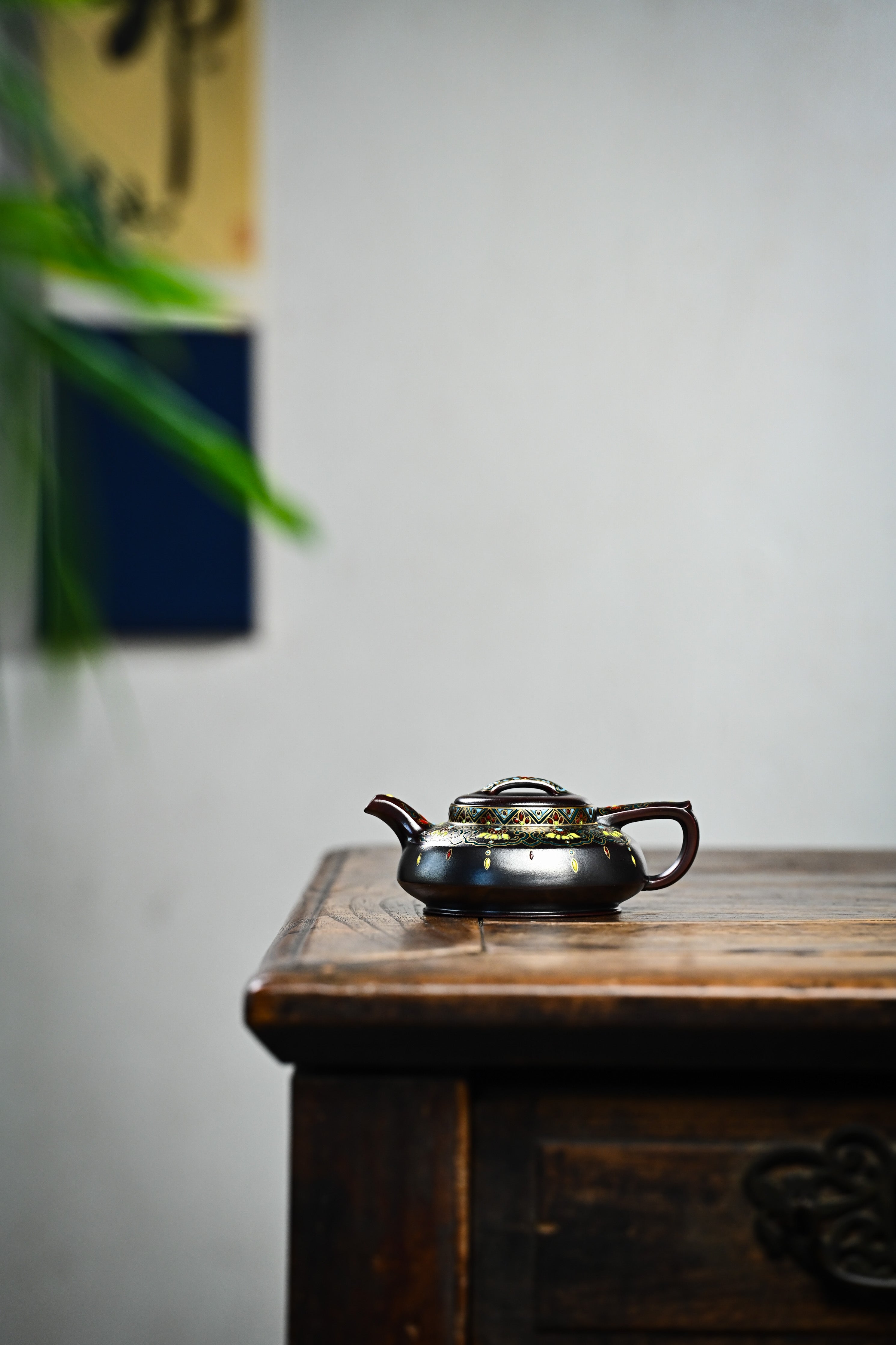 Handmade YANYOO Yixing teapot featuring Falangcai Ru Yi pattern, lifestyle wide-angle left side.