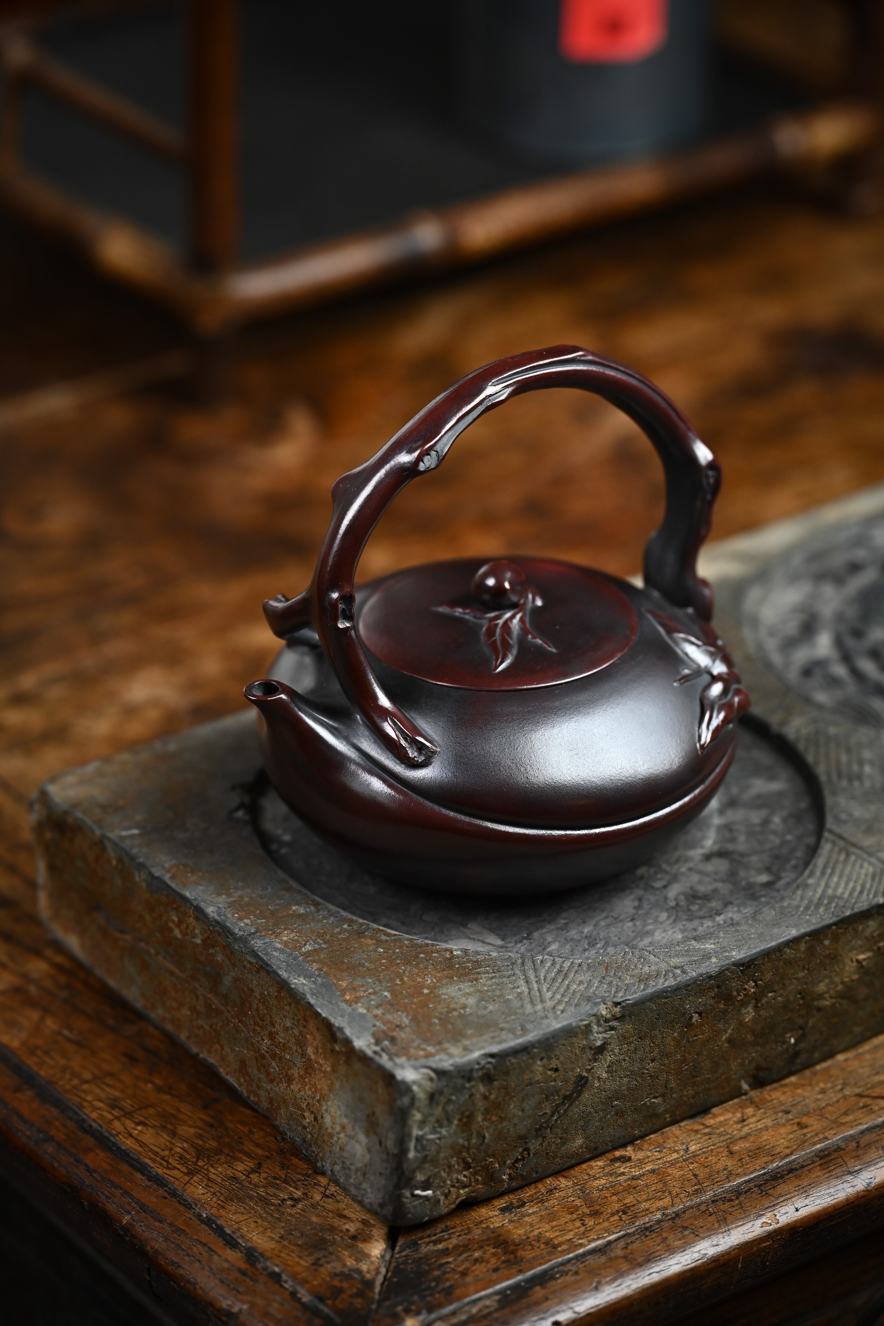 Handmade YANYOO Yixing teapot featuring aged Wuni clay and peach design, Shou Tao, lifestyle left side.