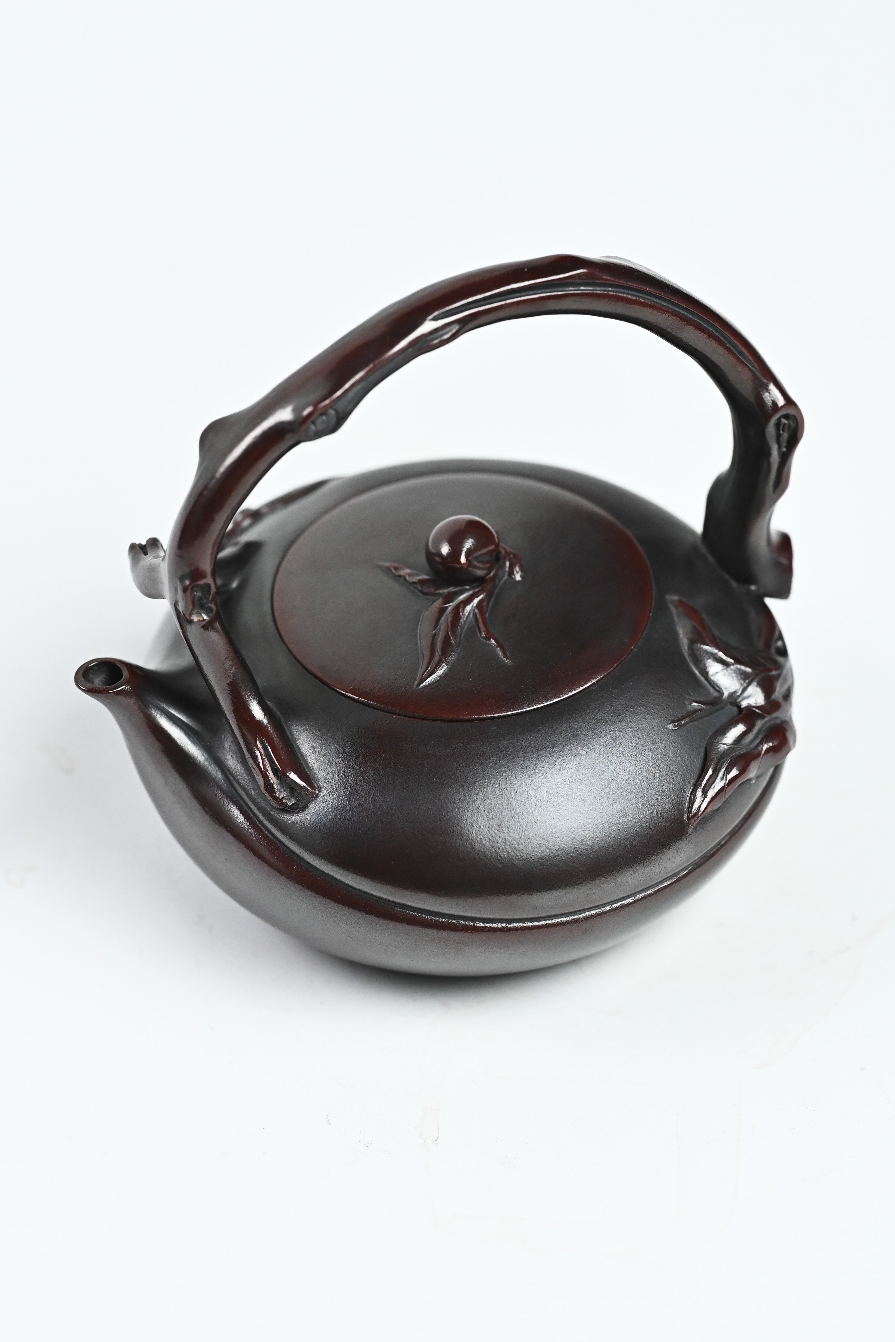 Handmade YANYOO Yixing teapot featuring aged Wuni clay and peach design, Shou Tao, product top side.