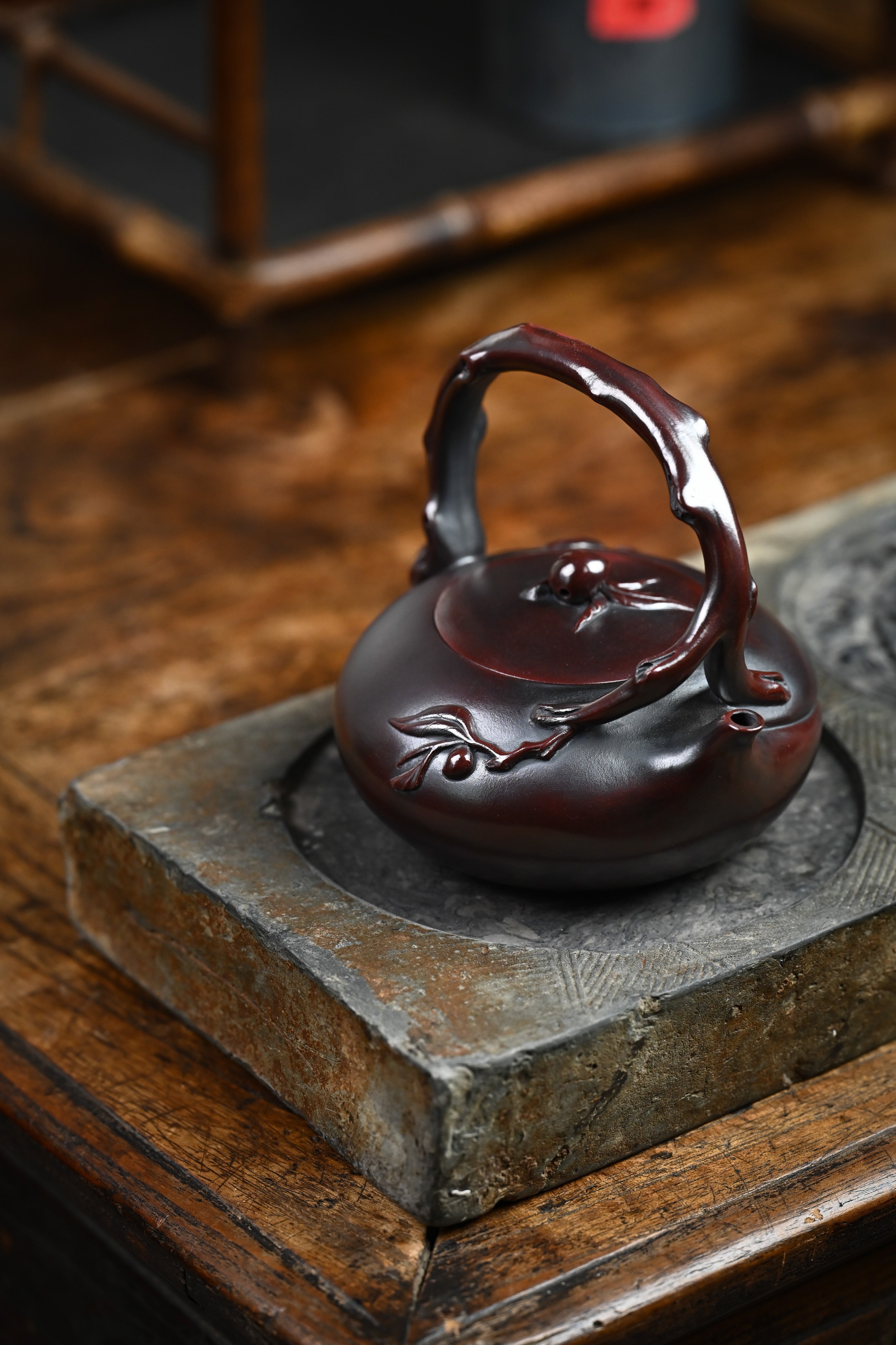 Handmade YANYOO Yixing teapot featuring aged Wuni clay and peach design, Shou Tao, lifestyle right side.