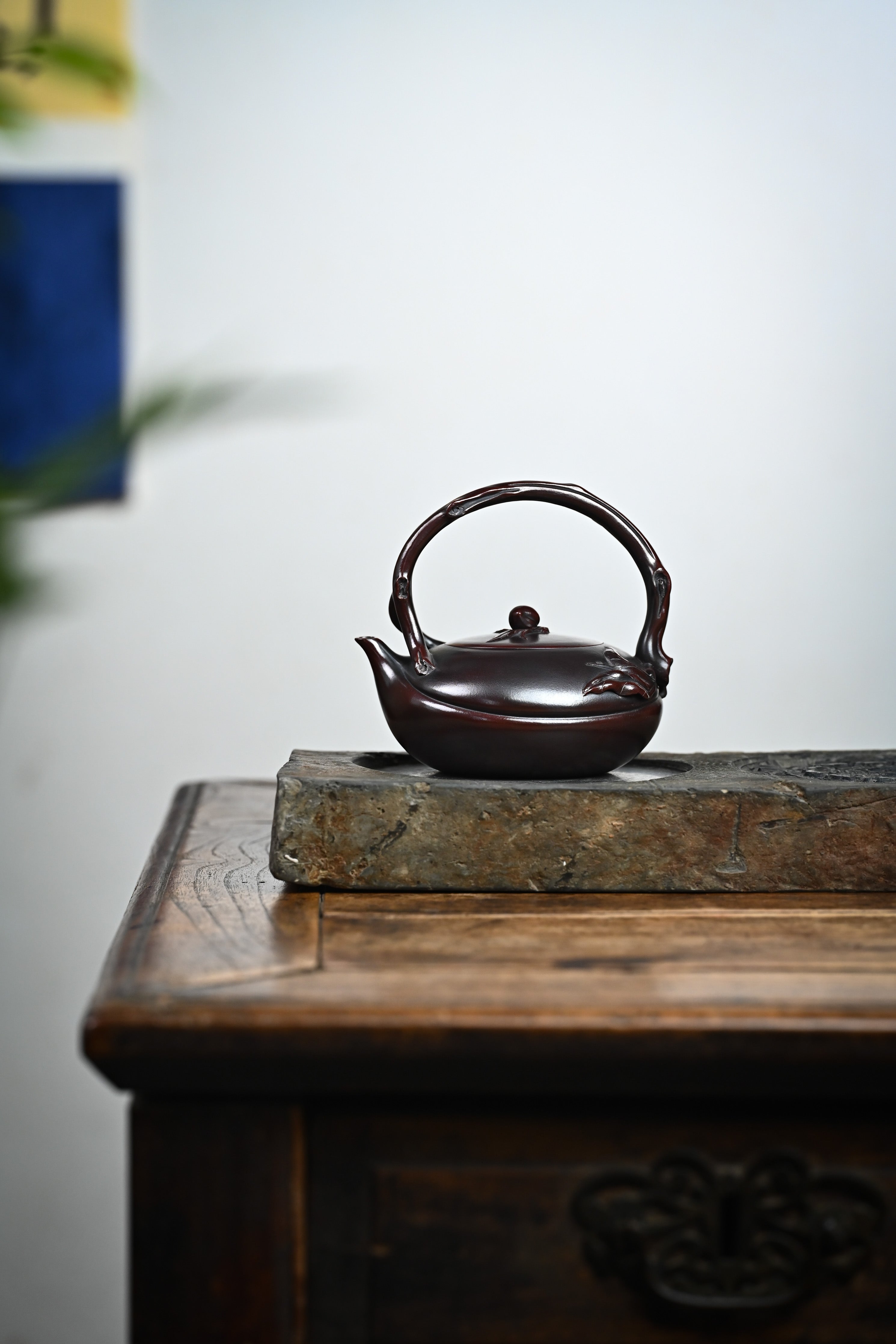 Handmade YANYOO Yixing teapot featuring aged Wuni clay and peach design, Shou Tao, lifestyle wide-angle left side.