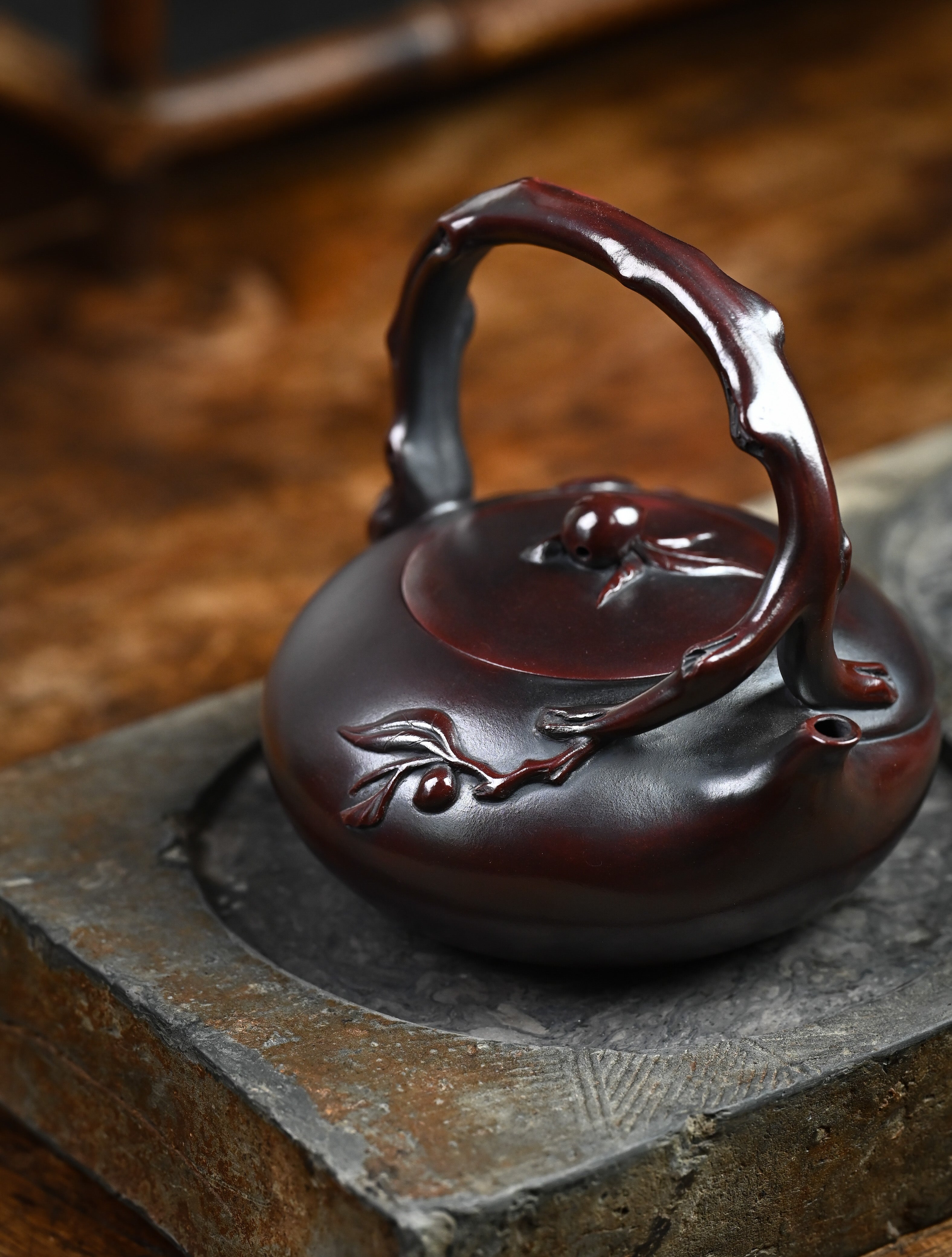 YANYOO handmade Yixing teapot featuring aged Wuni clay, lifting handle and peach sculpture, lifestyle right side.