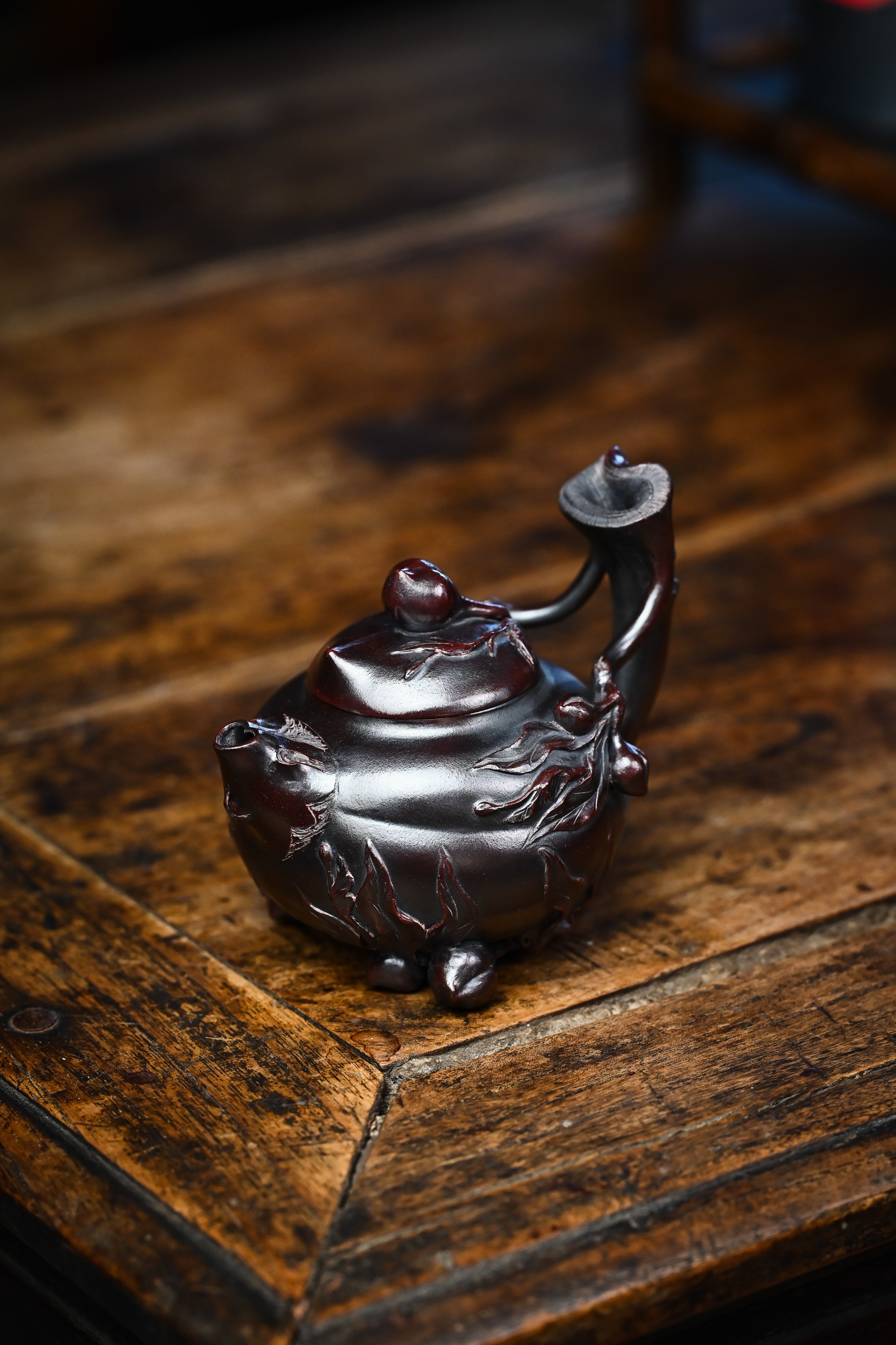 Handmade YANYOO Yixing teapot featuring aged Wuni clay and peach design, lifestyle left side.