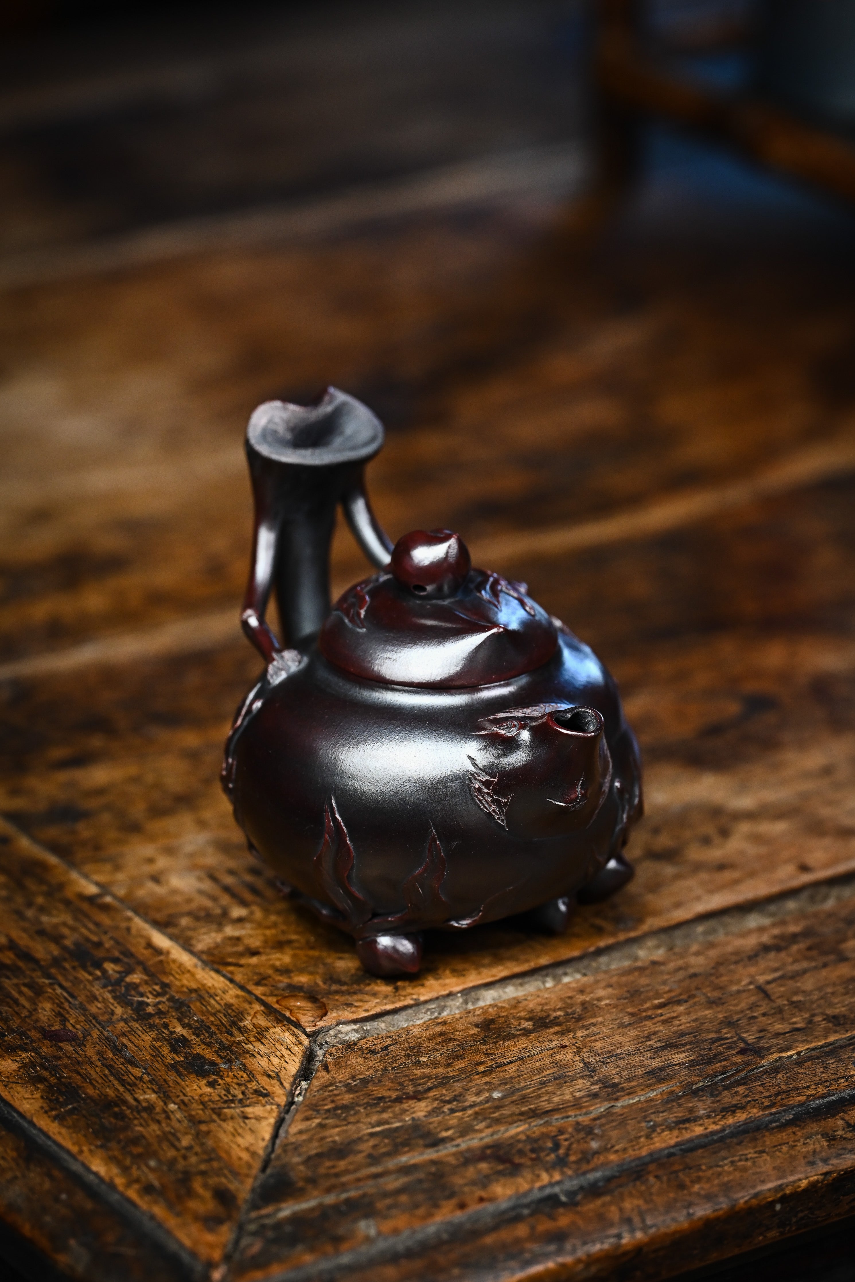 Handmade YANYOO Yixing teapot featuring aged Wuni clay and peach design, lifestyle right side.