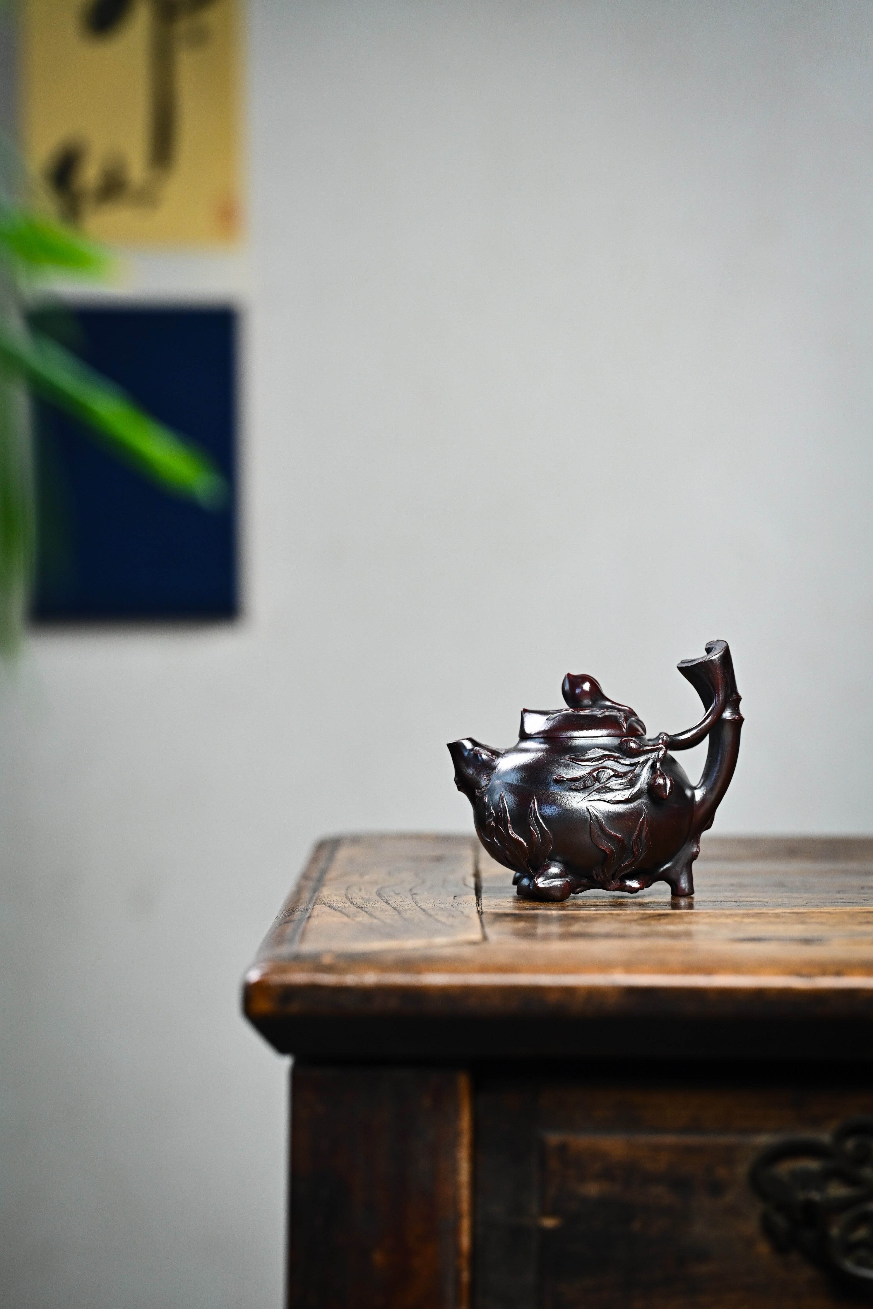 Handmade YANYOO Yixing teapot featuring aged Wuni clay and peach design, lifestyle wide-angle left side.