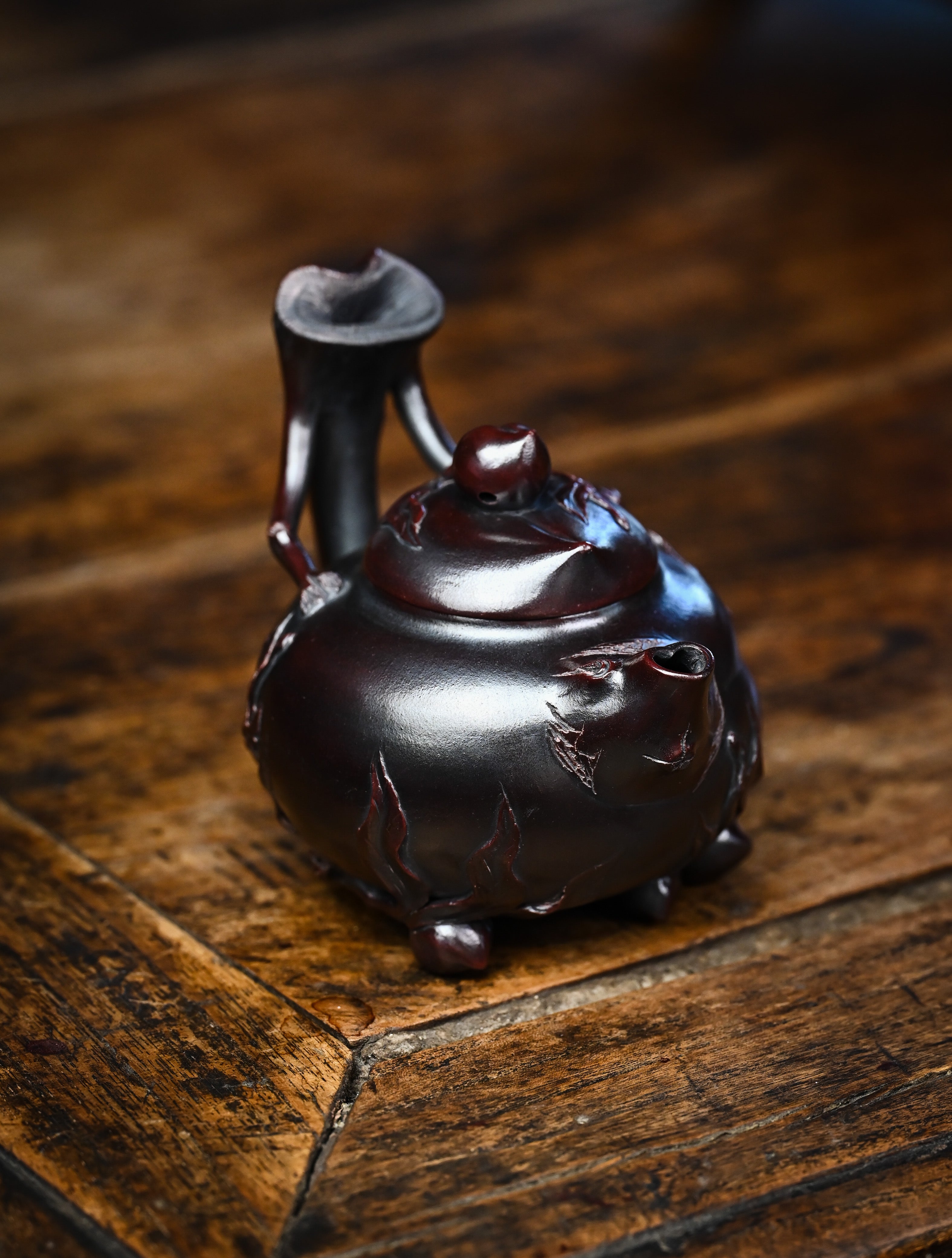 YANYOO handmade Yixing teapot featuring aged Wuni clay and peach sculpture, lifestyle right side.